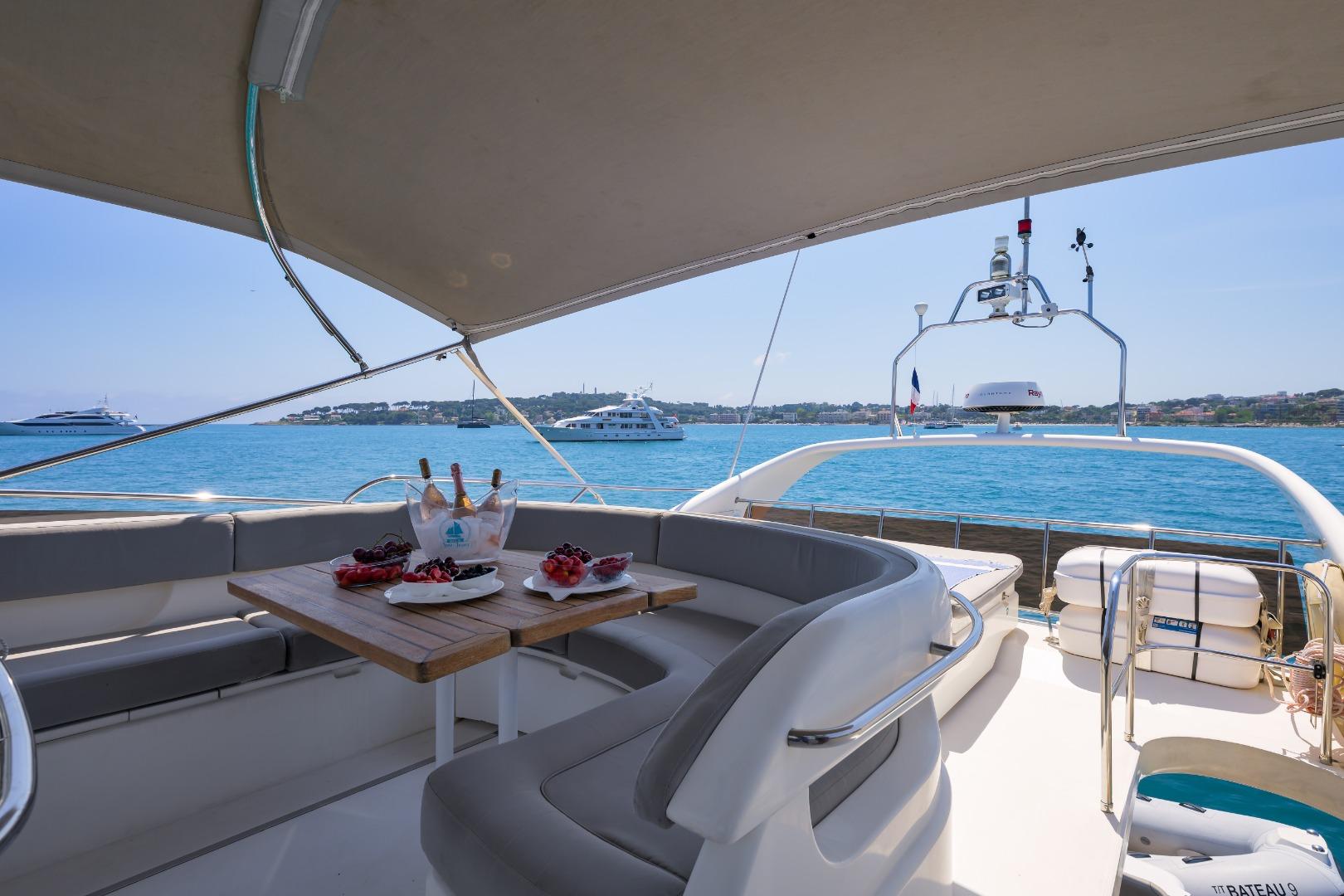 Luxurious 2001 Princess 61 yacht deck with dining setup, overlooking serene blue waters.