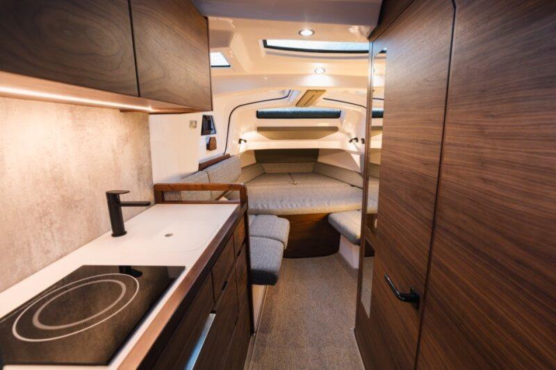 Luxurious interior of 2026 Axopar 38 Cross Cabin with modern kitchen and cozy seating area.