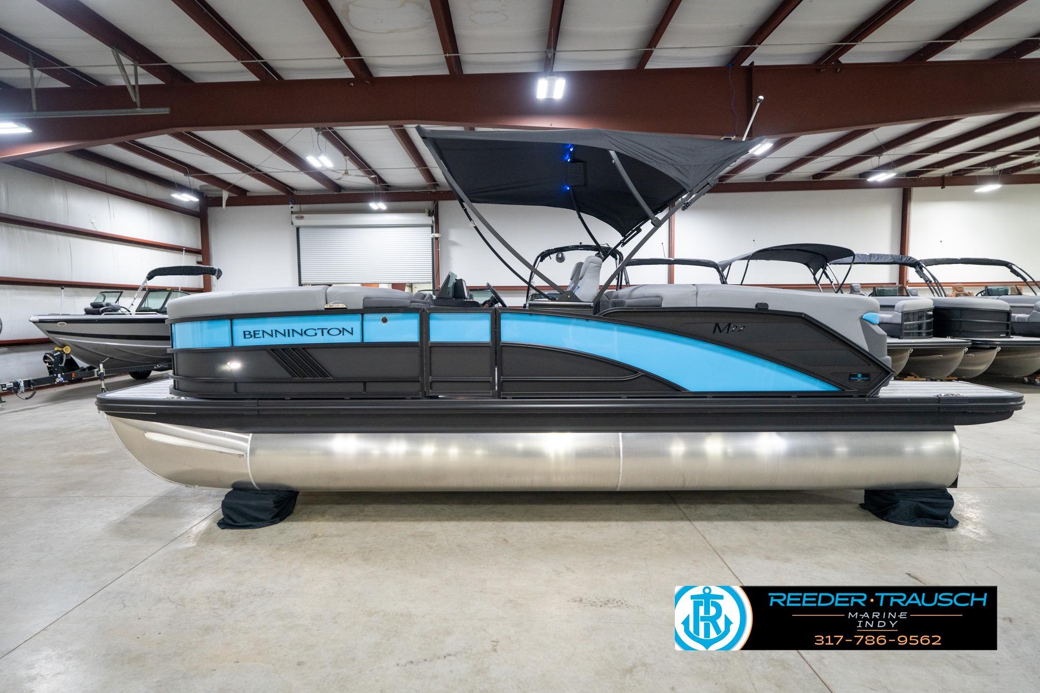 2026 Bennington 22 MFB pontoon boat in showroom, featuring sleek design and blue accents.