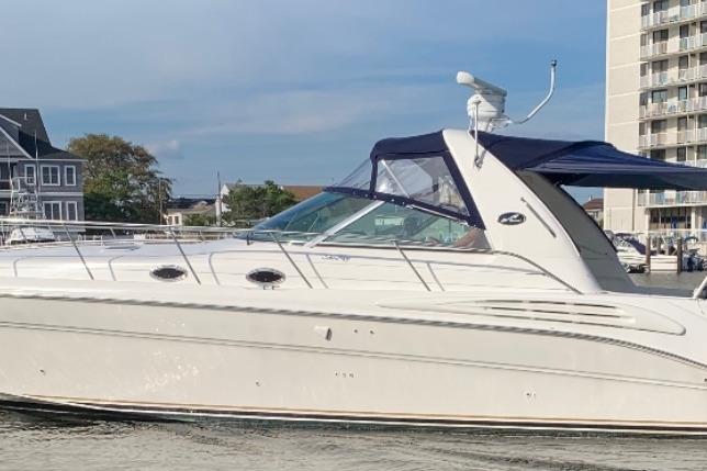 1999 Sea Ray Sundancer 400 yacht docked near waterfront buildings.