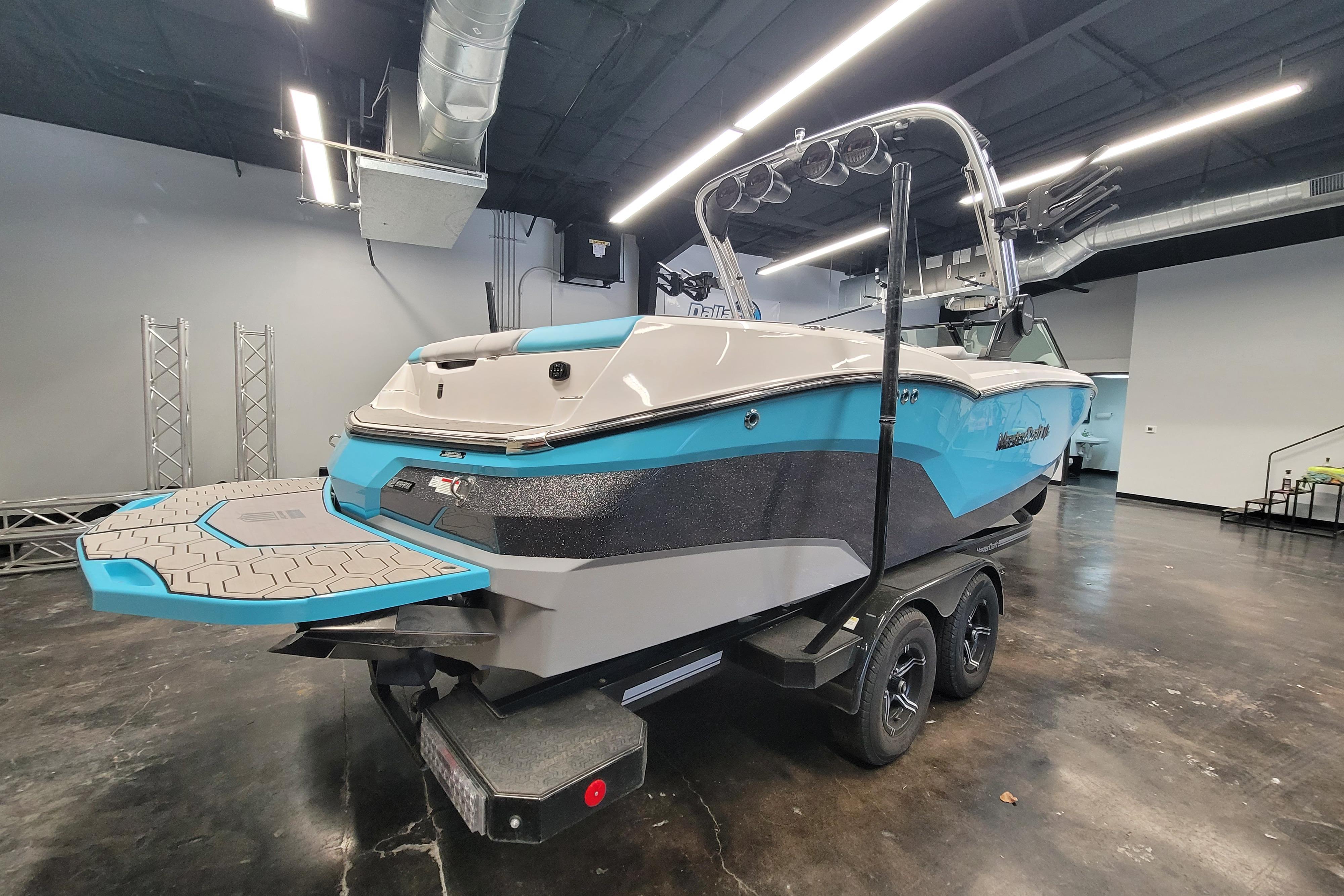 2024 MasterCraft NXT24 boat in showroom, featuring sleek design and vibrant blue accents.