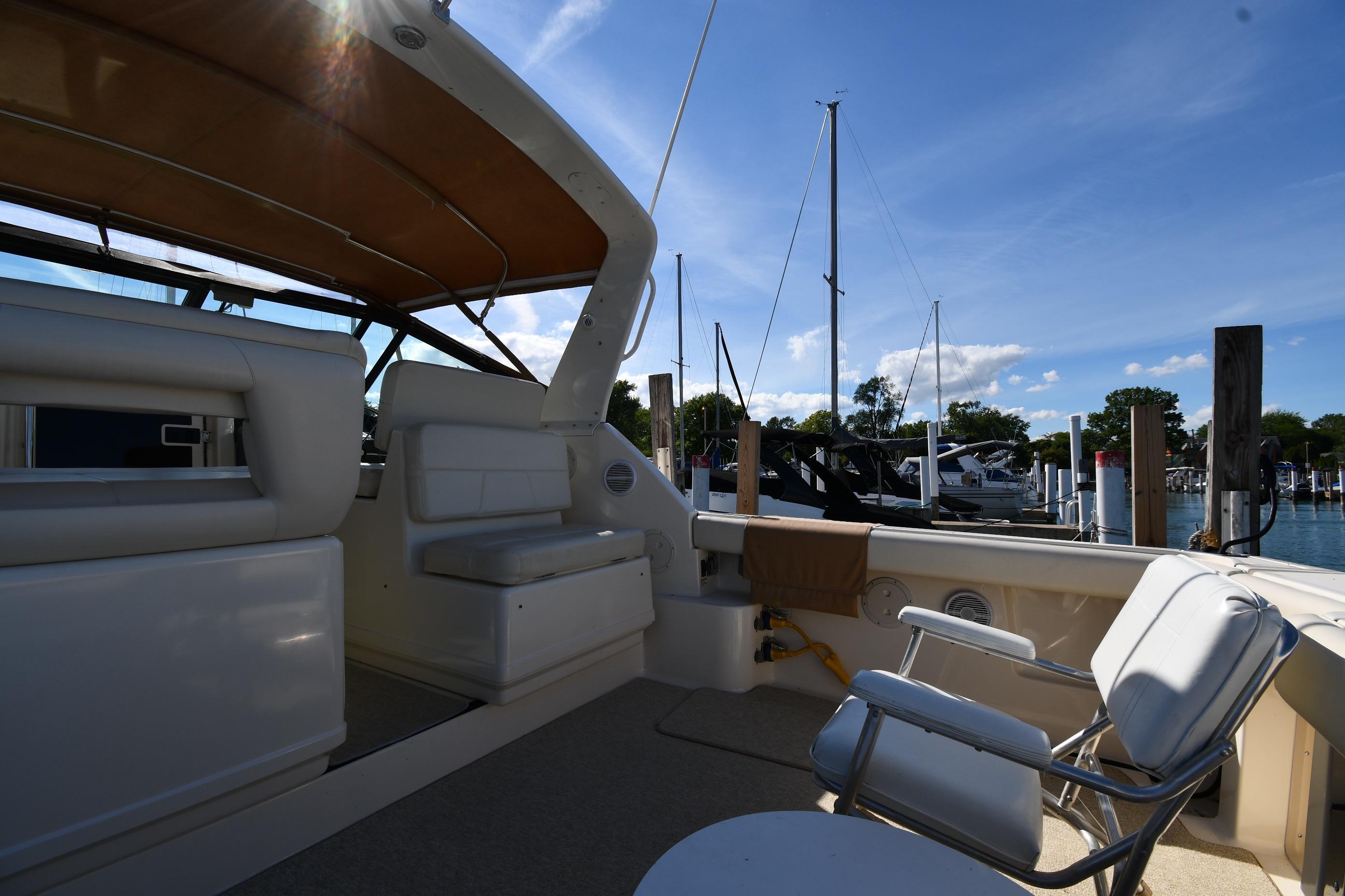 1998 Tiara Yachts 3100 Open interior with seating, docked at marina under clear blue sky.