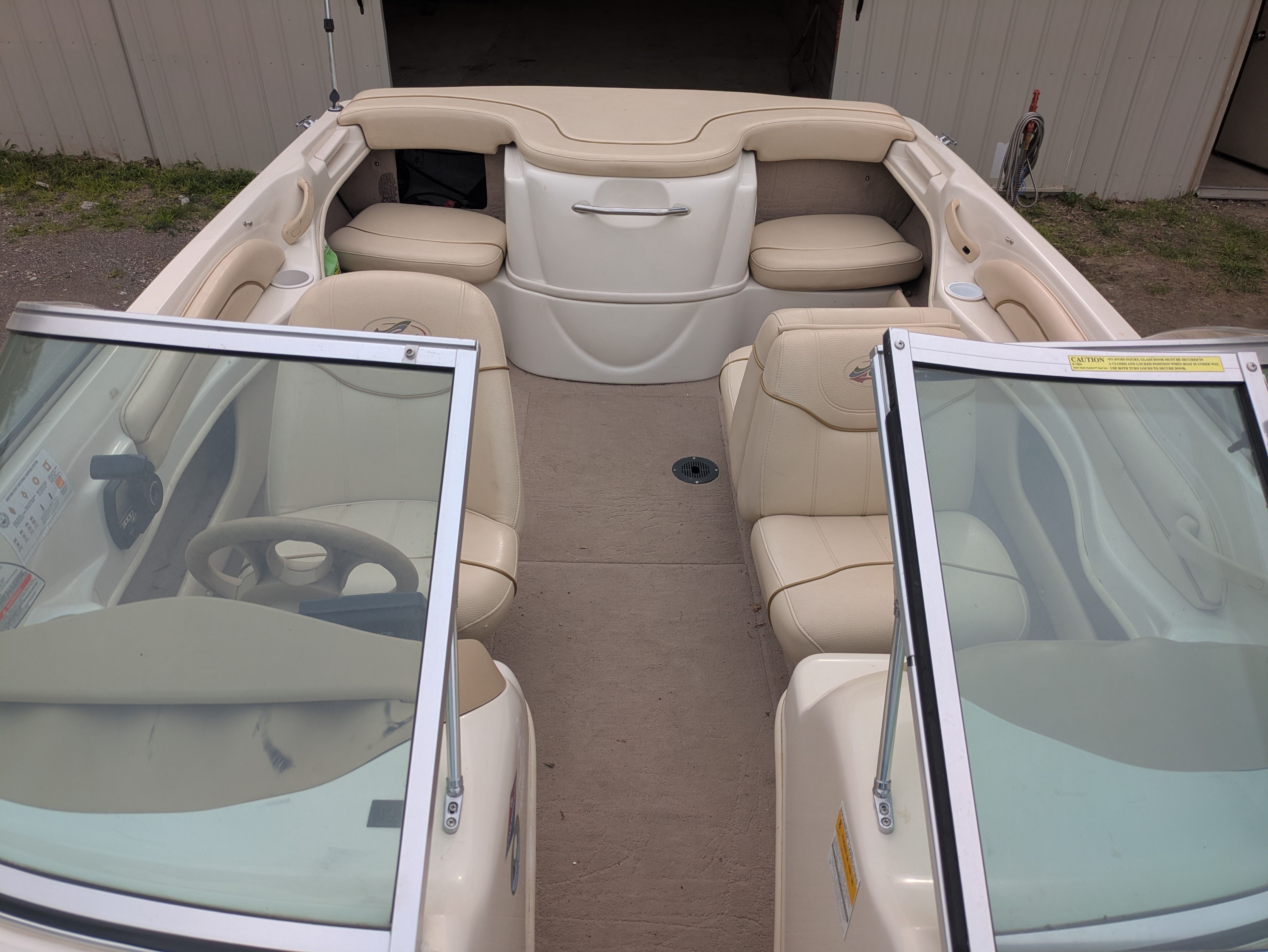 Interior view of a Sea Ray 185 Bow Rider boat with beige seats and windshield.