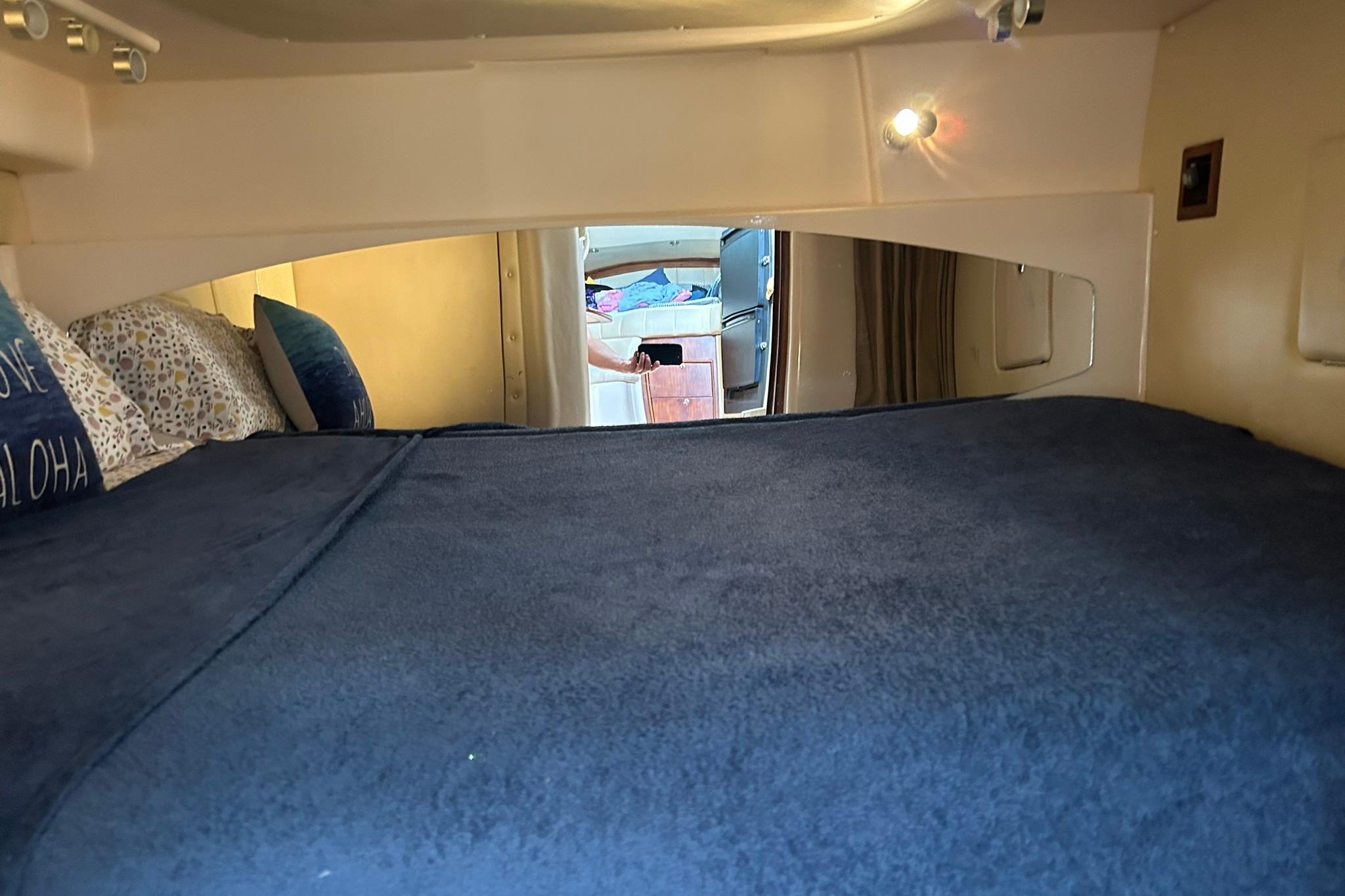 2007 Grady-White Express 360 cabin interior with cozy bedding and ambient lighting.
