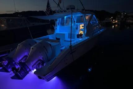2020 Pursuit OS 325 Offshore boat illuminated with blue lights at night.