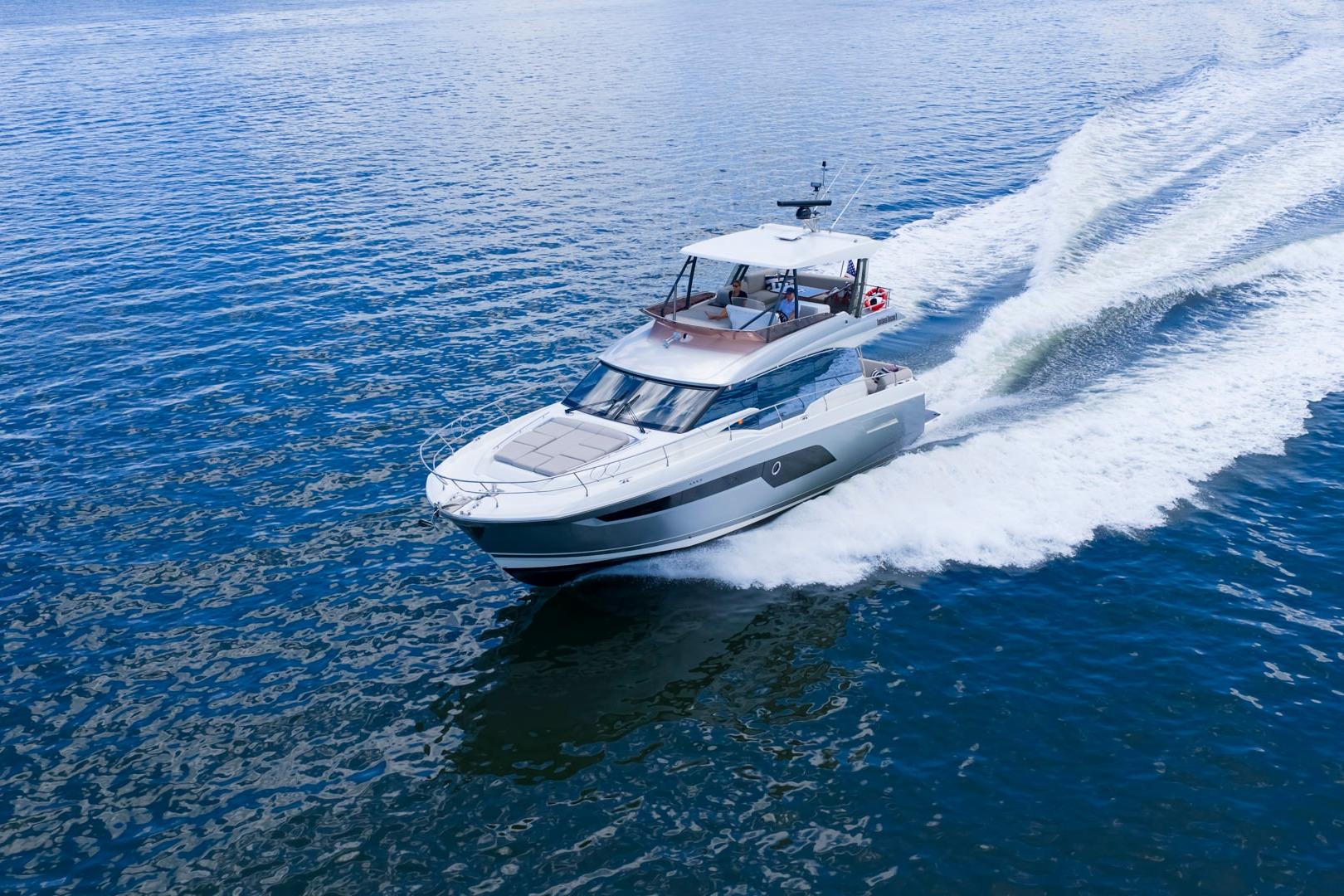2022 Prestige 520 yacht cruising on open water, creating a dynamic wake.