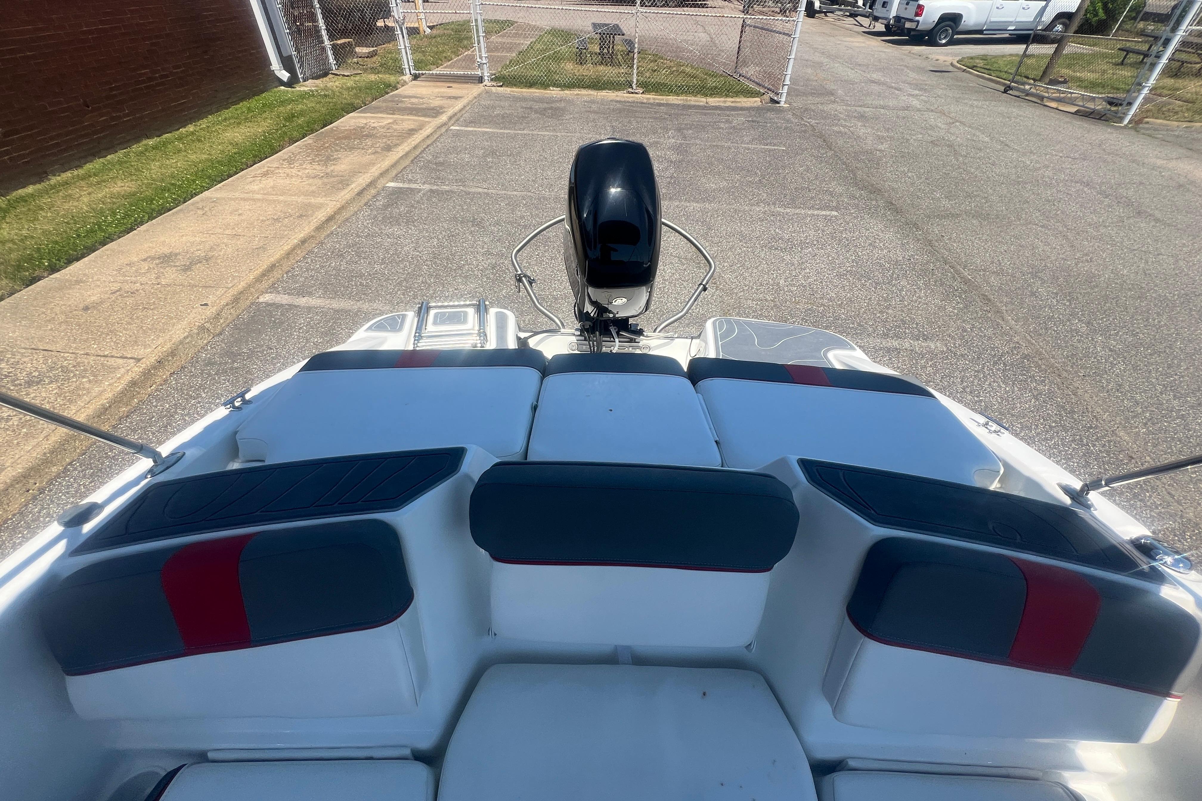 2023 Tahoe T16 boat with cushioned seating and outboard motor in a parking area.