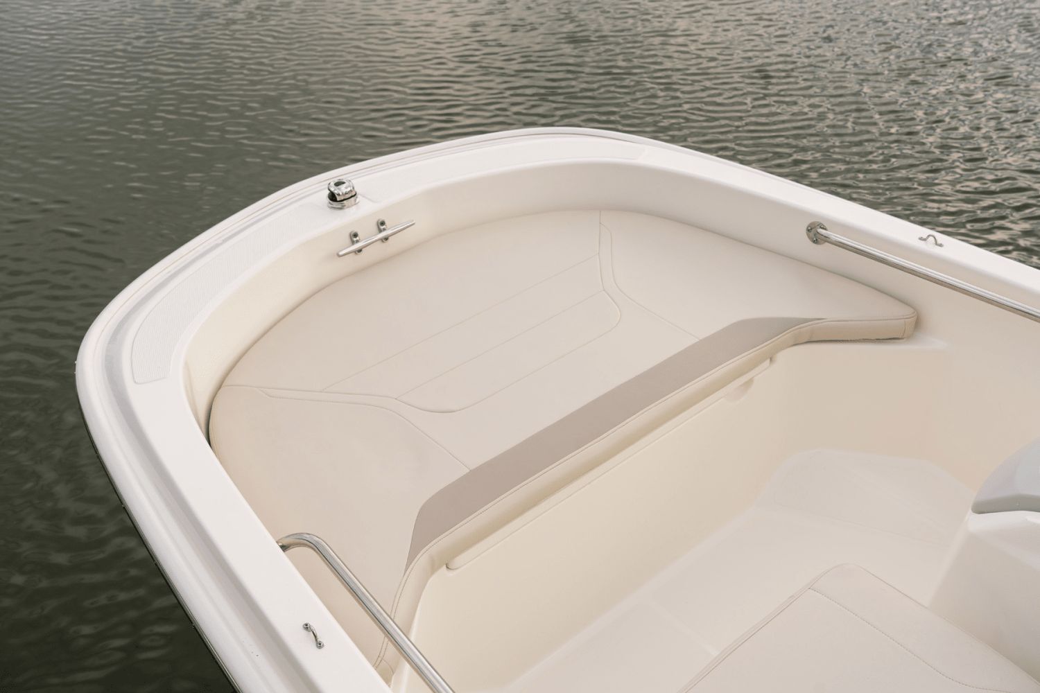 The image shows the bow of a 2026 Boston Whaler 130 Super Sport on calm water.