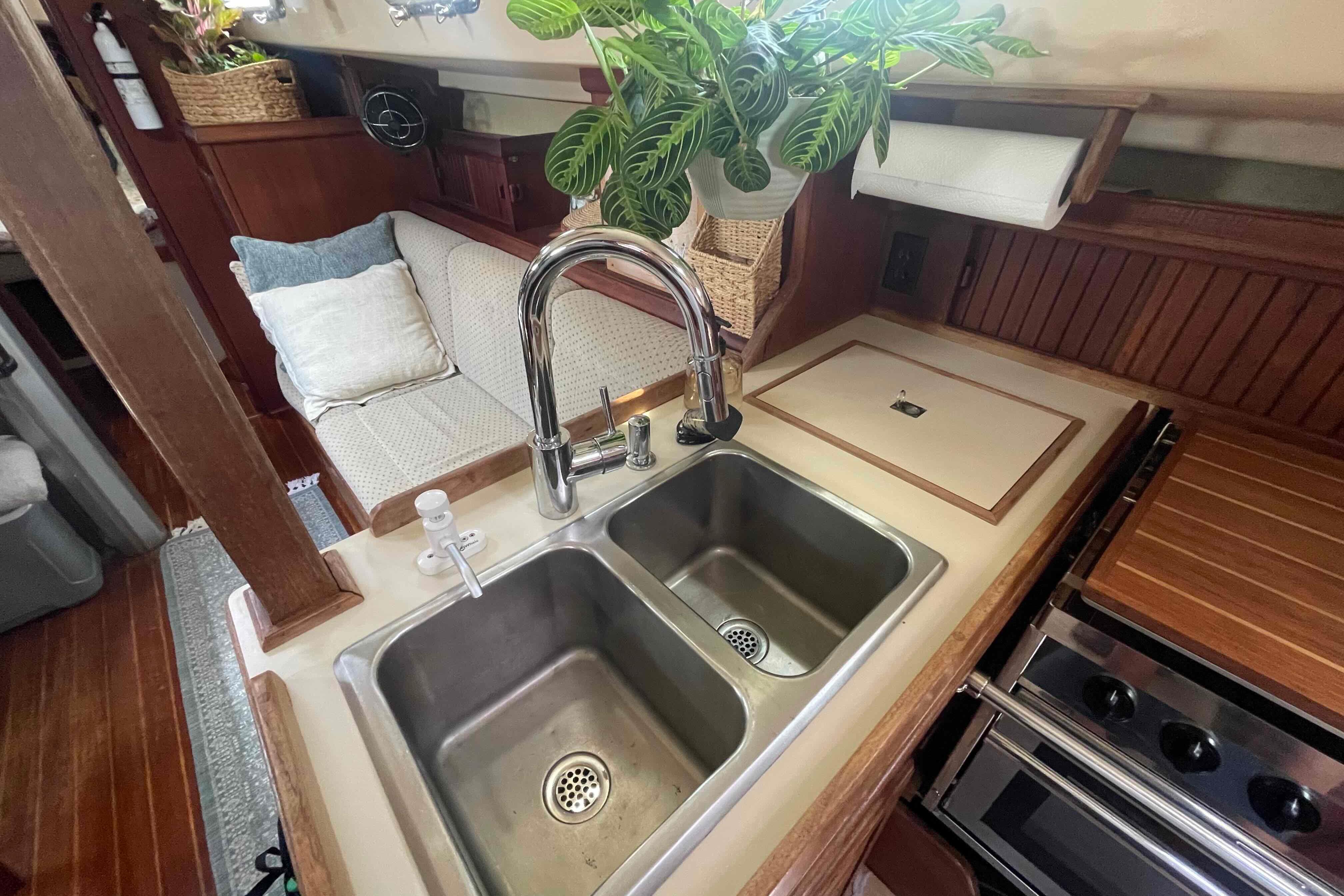 Interior of 1989 Island Packet 35 sailboat with kitchen sink and cozy seating area.