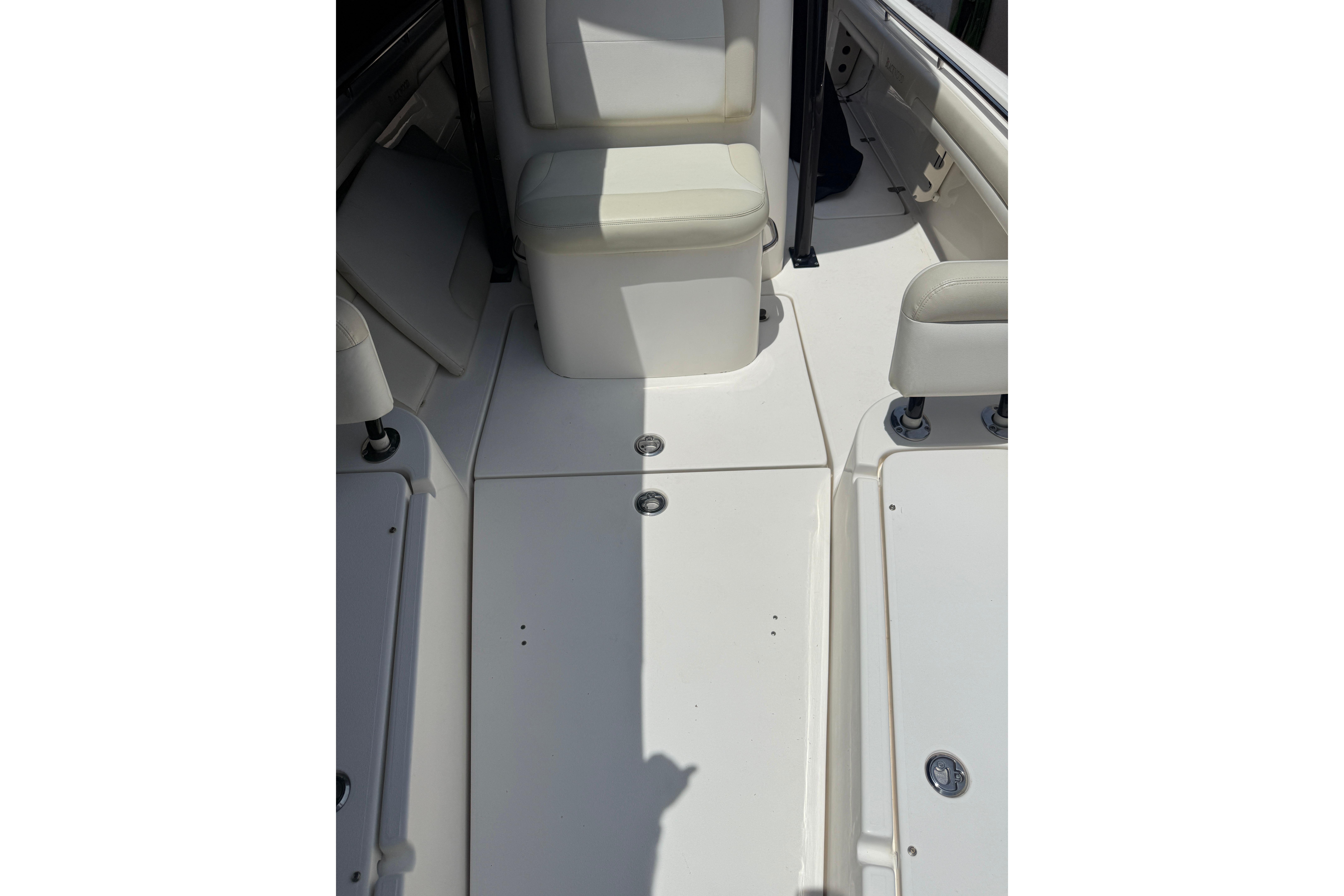 Interior view of a 2015 Blackwood 27 boat, featuring white seating and deck.