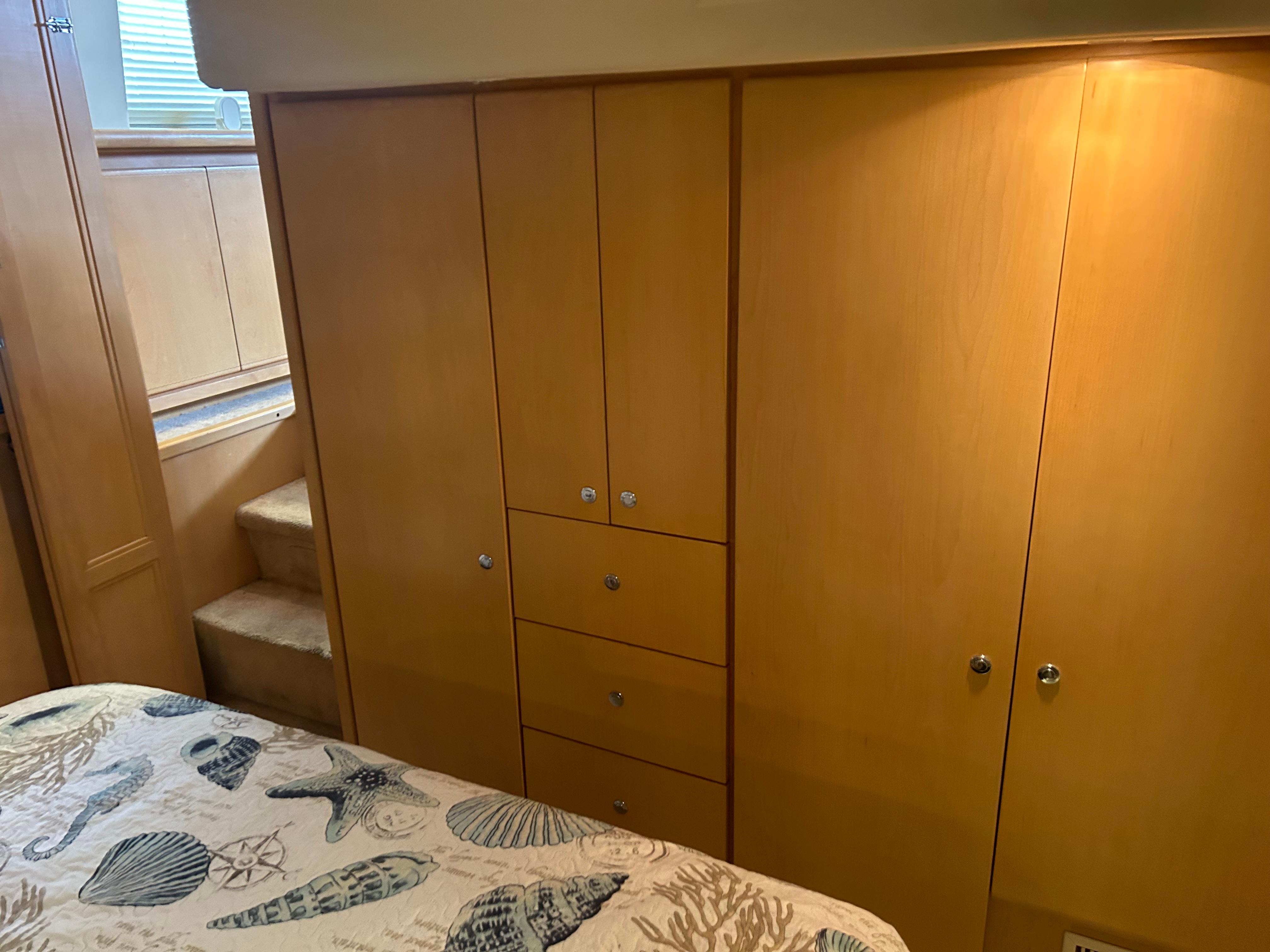 Interior of 1996 Carver 440 Aft Cabin Motor Yacht with wooden cabinetry and patterned bedding.