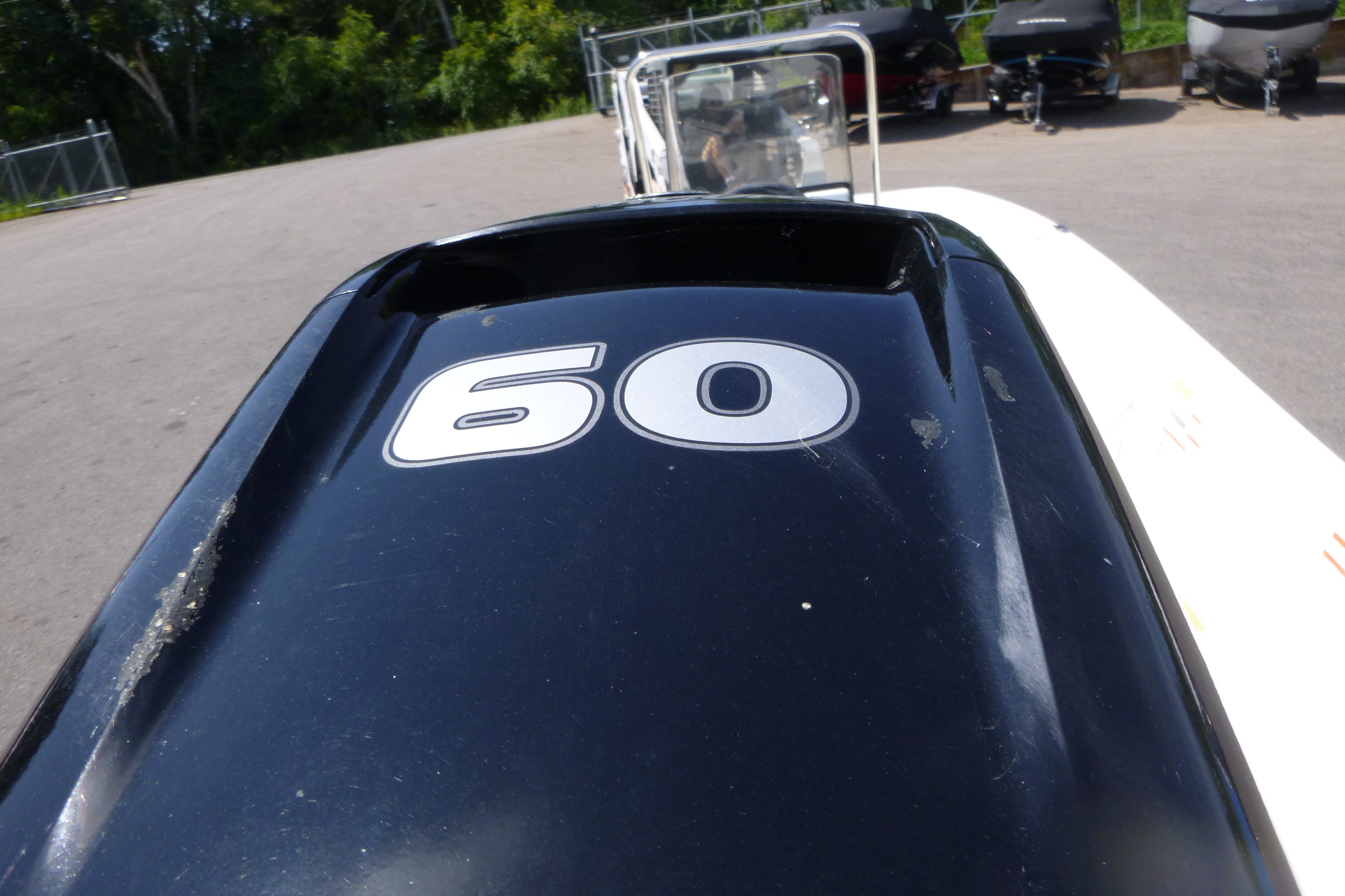 2024 Mako Pro Skiff 17 CC with 60 HP engine, parked outdoors.