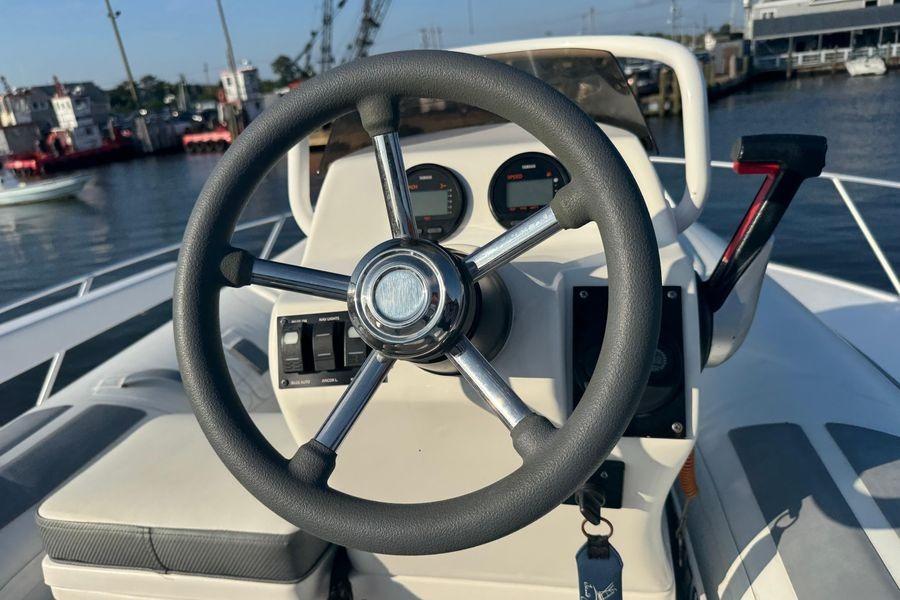 Steering wheel of a 2002 Viking 61 Enclosed Bridge yacht, docked at a marina.