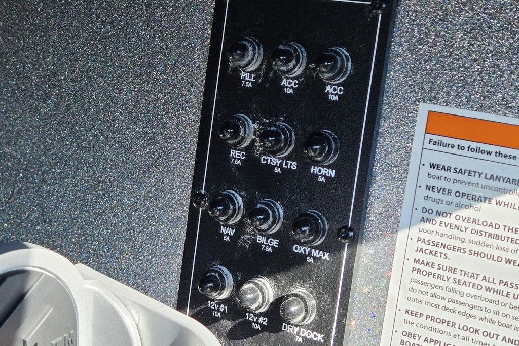 Control panel of a 2026 Skeeter ZXE20 boat with labeled switches and safety instructions.