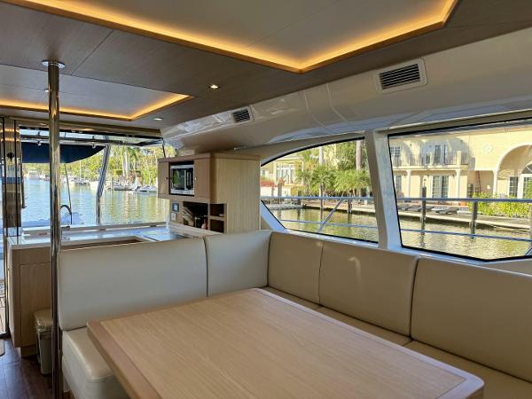 Luxurious interior of 2022 Aquila 44 yacht with spacious seating and scenic marina view.
