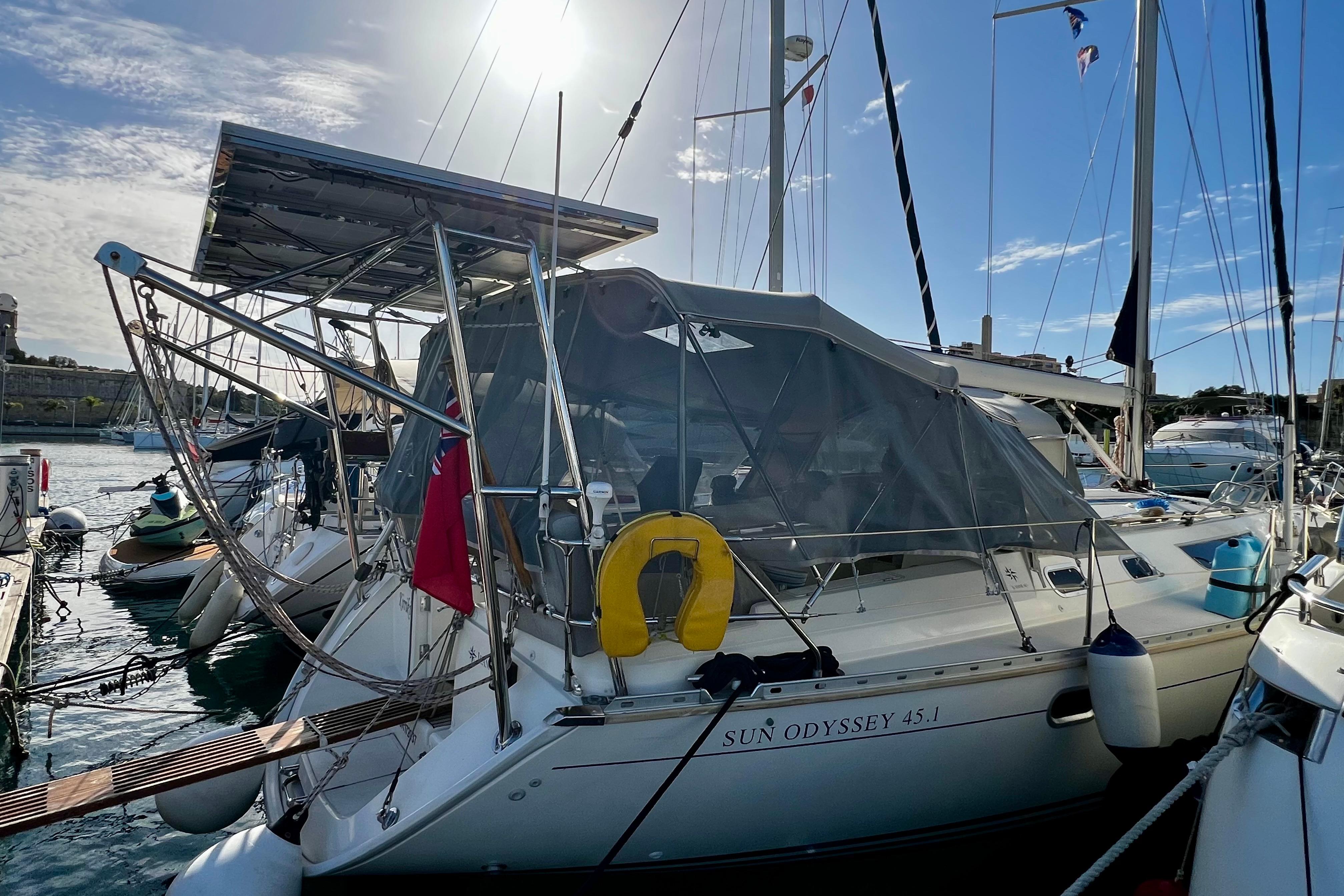 1995 Jeanneau Sun Odyssey 45.1 sailboat docked in a marina under sunny skies.
