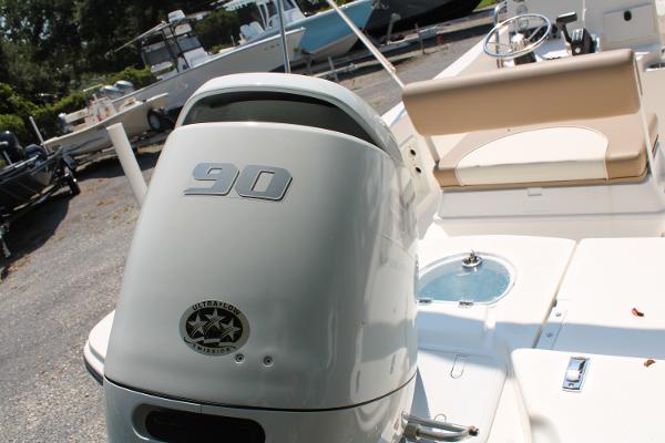 2023 Sundance DX20 boat with 90 horsepower engine, docked outdoors.
