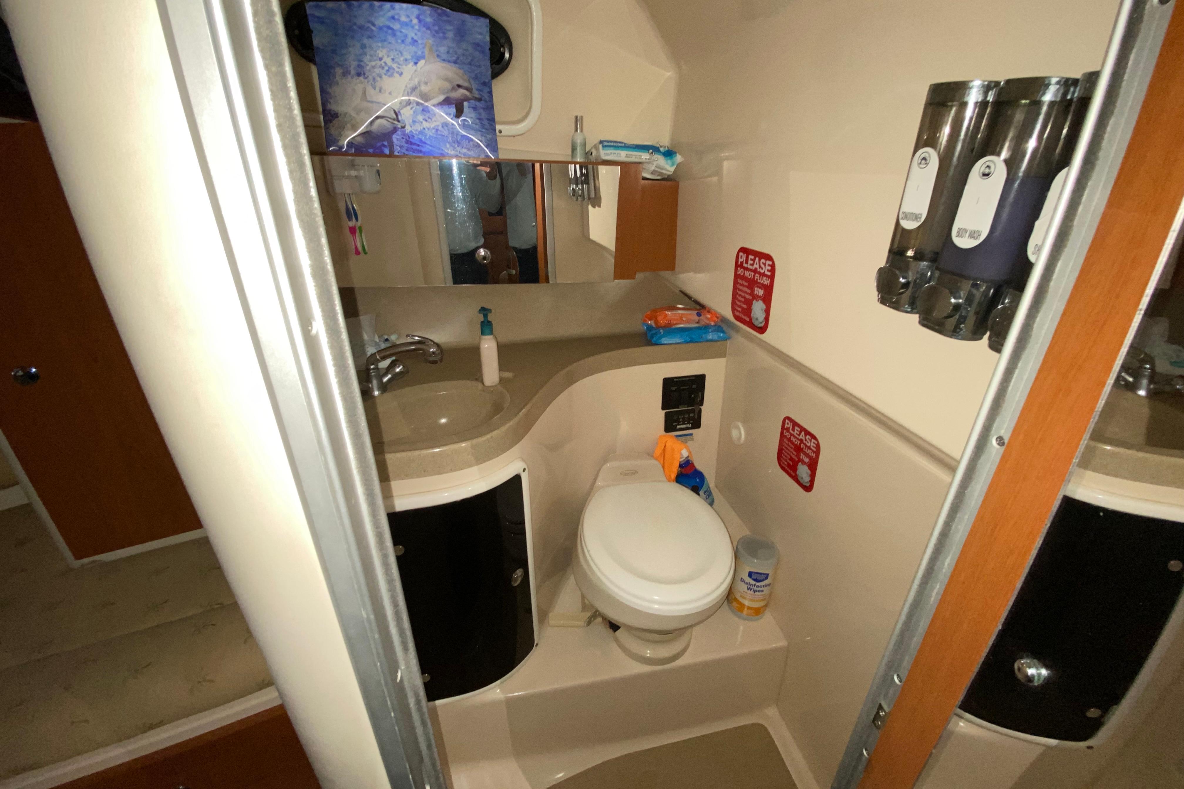 2005 Wellcraft 290 Coastal boat bathroom with sink, toilet, and toiletries.