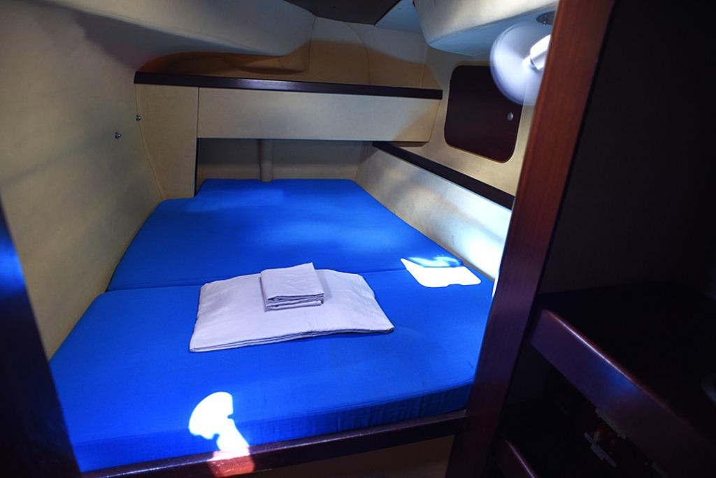 Cozy cabin interior of 1997 Fountaine Pajot Athena 38 with blue bedding.