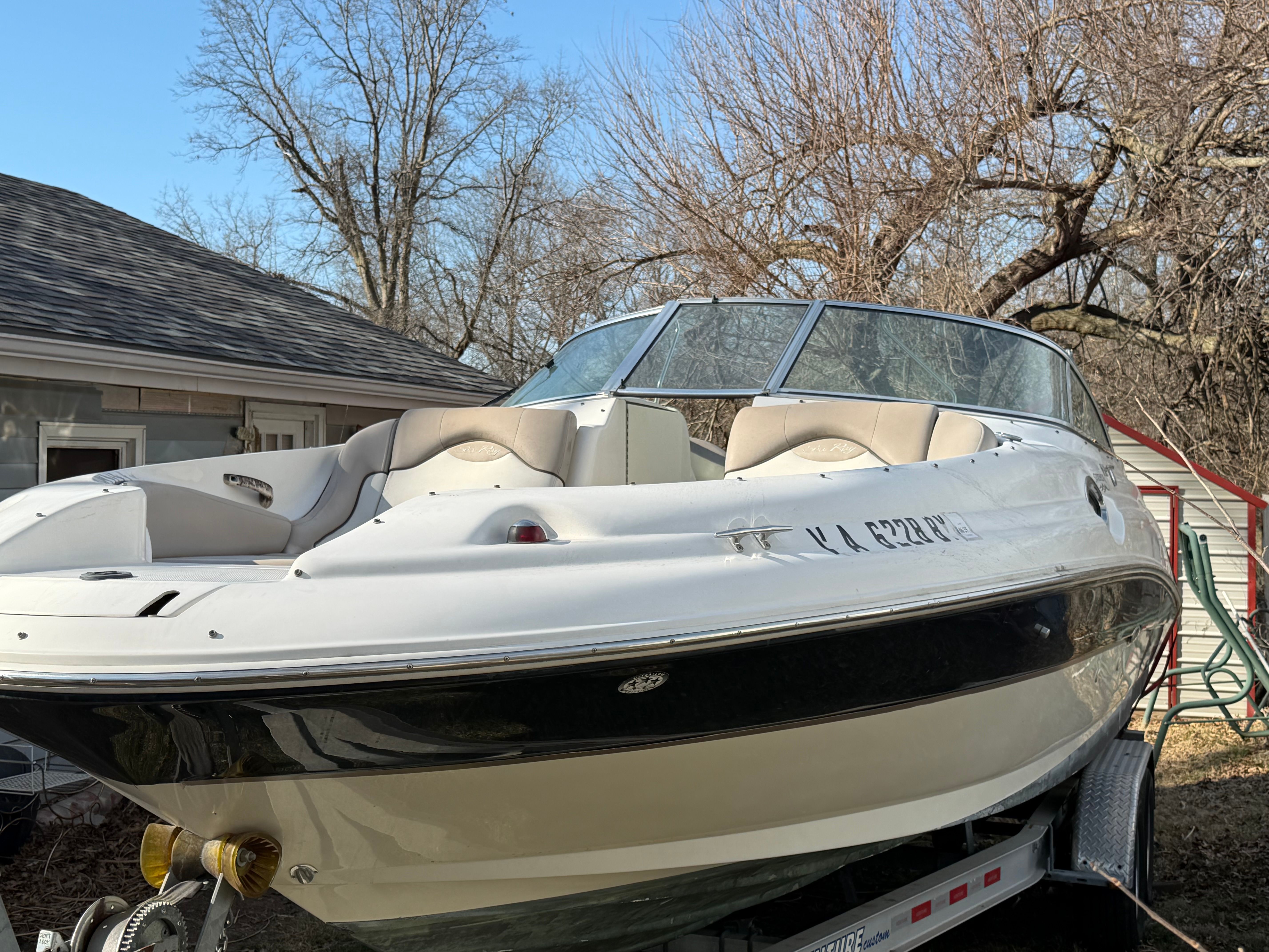 2004 Sea Ray 270 Sundeck on trailer, parked outdoors.