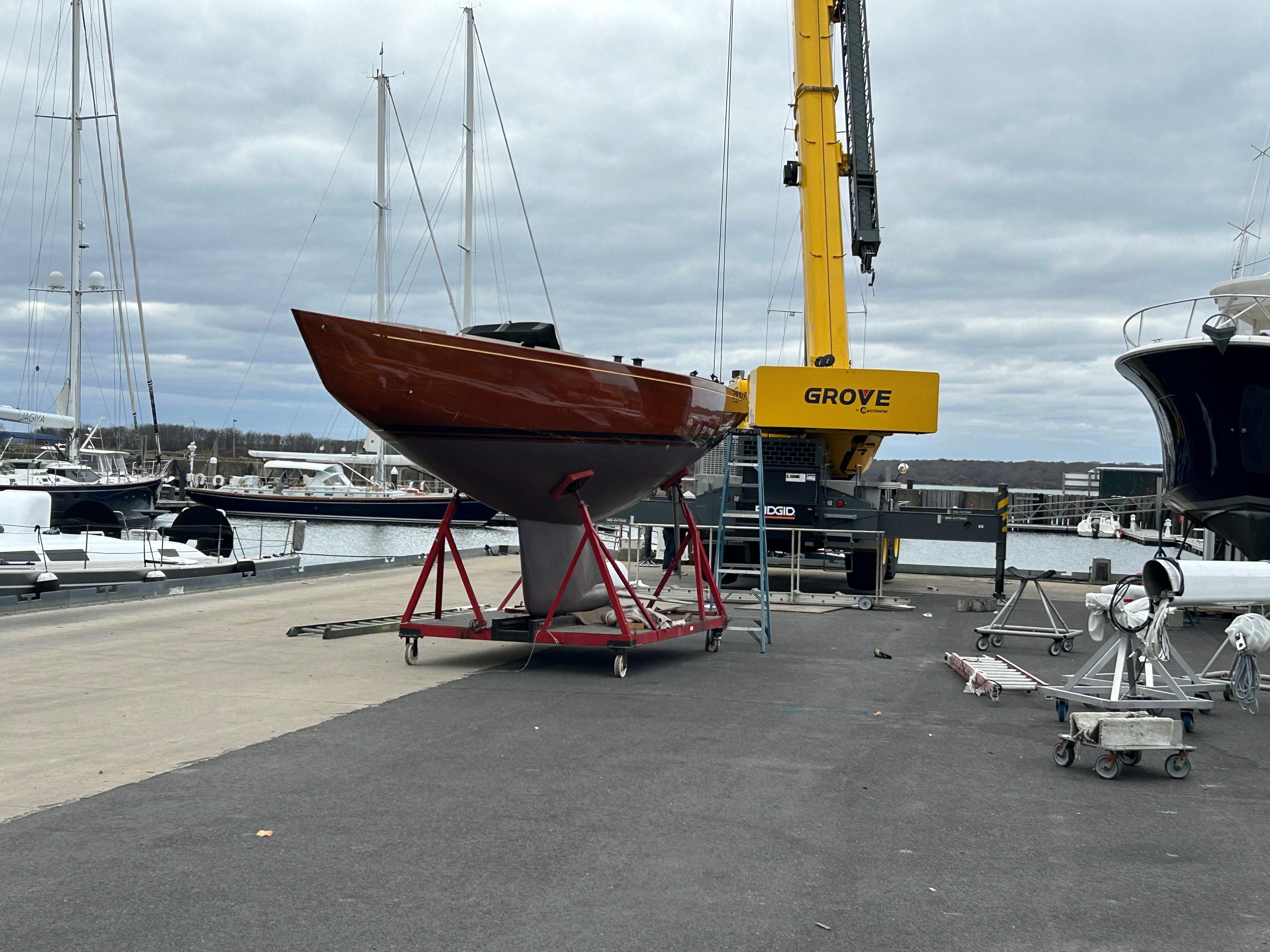 A 1989 Litton International 6 Metre yacht on a stand near a marina crane.