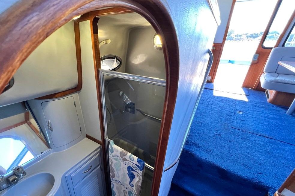 Interior of 1990 Mediterranean 38 Sport Fisher yacht with bathroom and seating area.