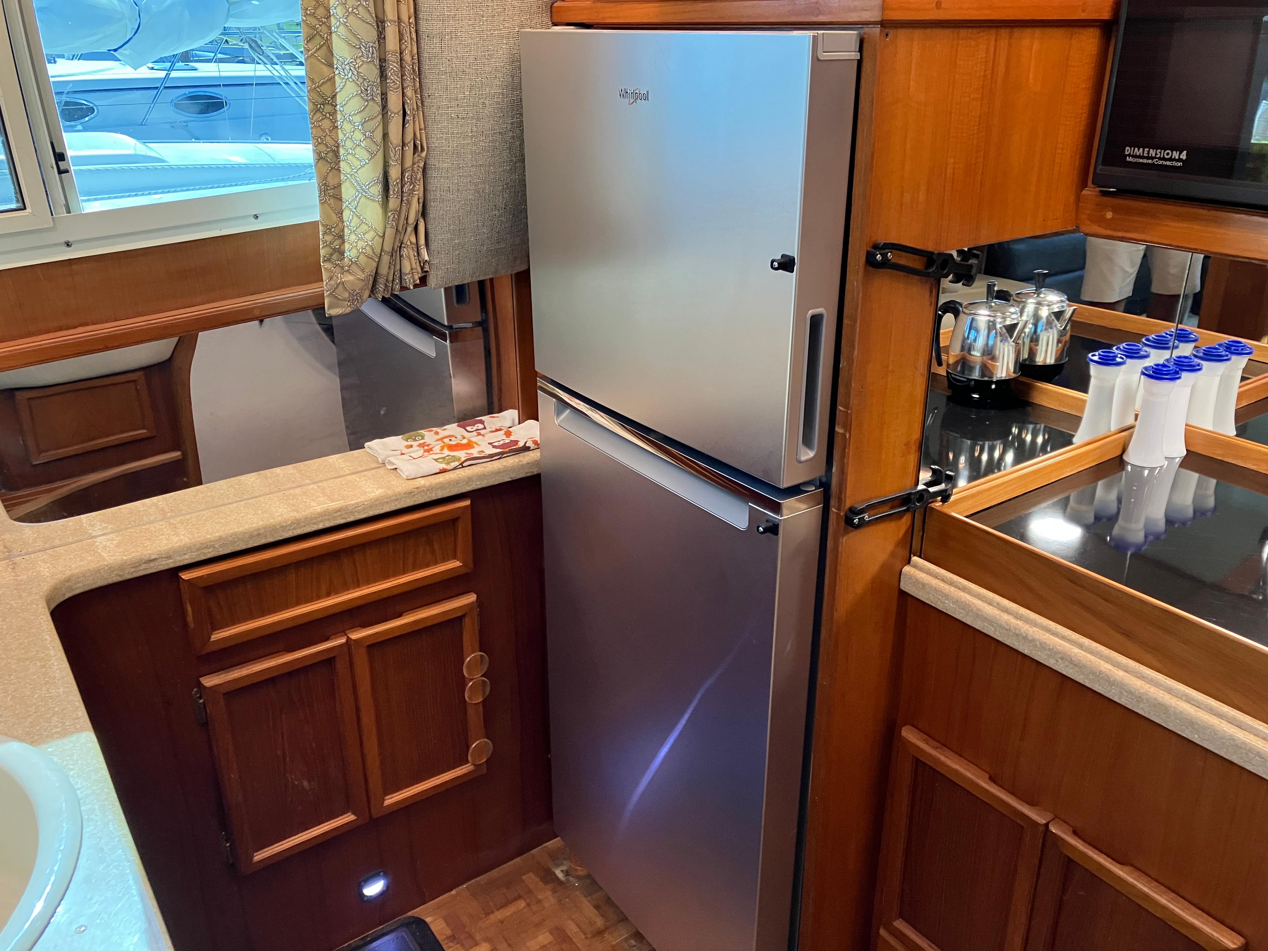Kitchen area of a 1995 Egg Harbor 42 yacht with stainless steel fridge.