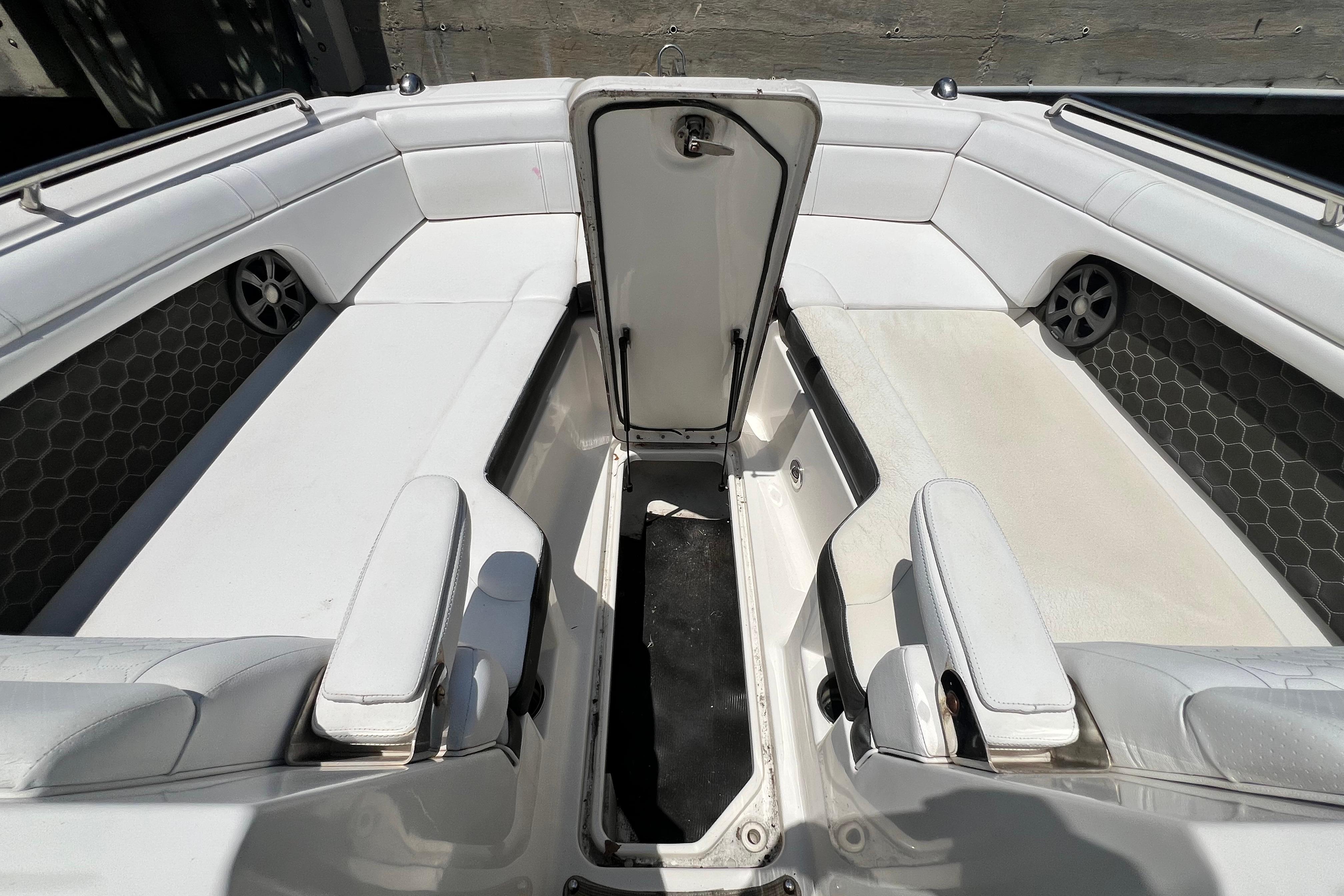 2019 Sea Ray SDX 270 Outboard interior with open storage compartment and white seating.