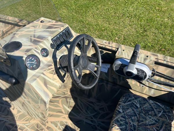 2025 Lowe Roughneck 2070 SC boat interior with camo design and steering console.