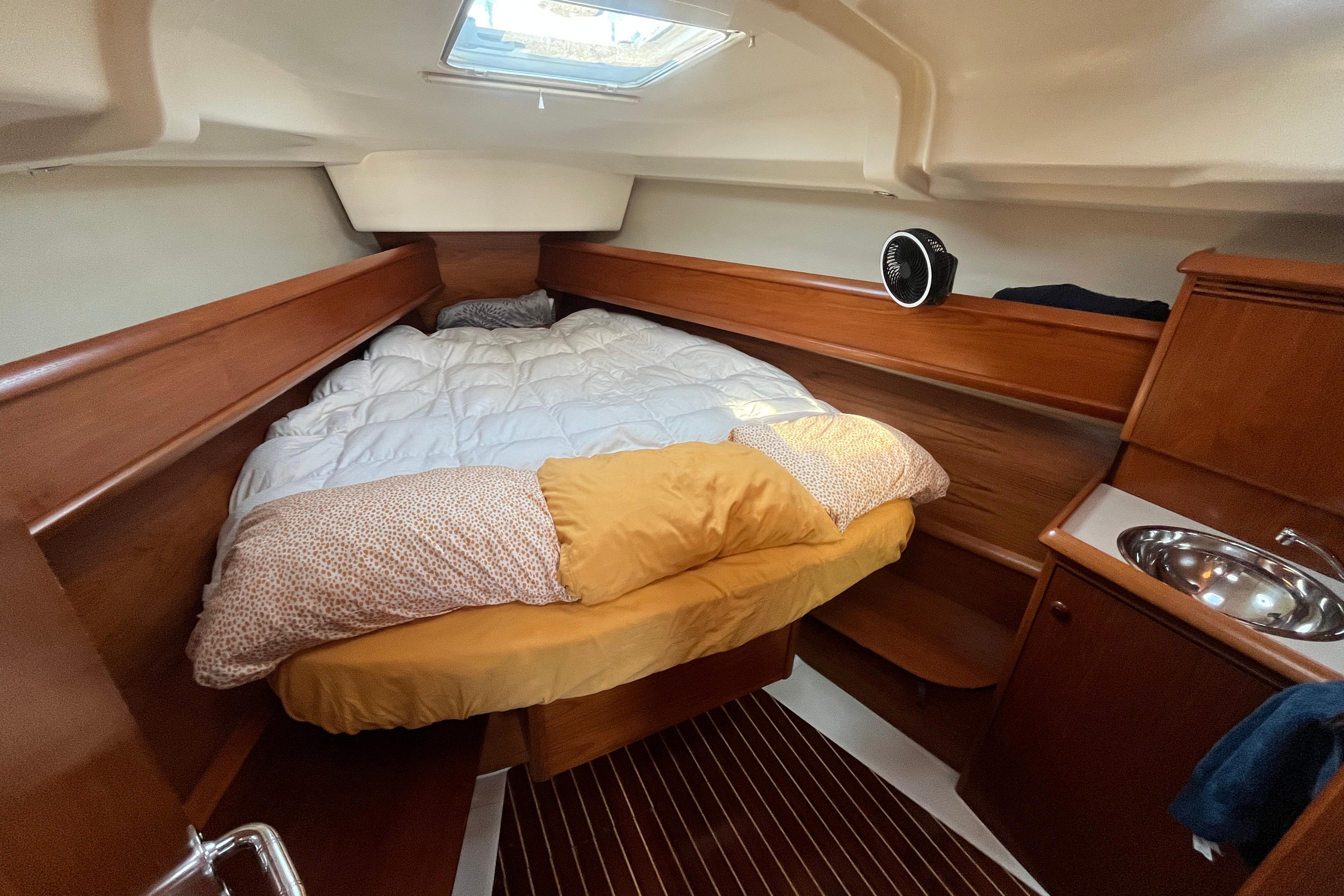 Cozy cabin interior of 2005 Jeanneau Sun Odyssey 40.3 sailboat with bed and sink.