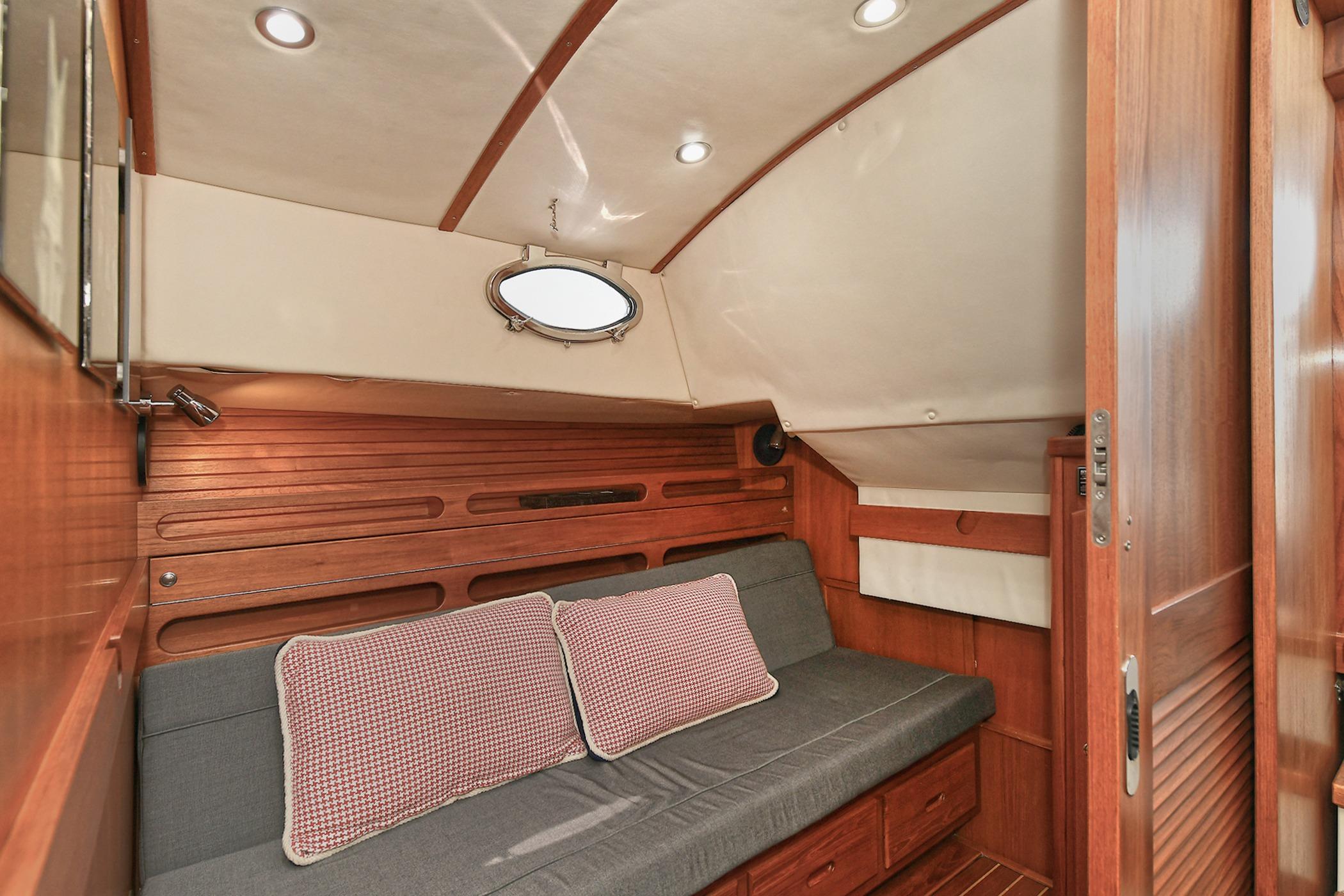 Cozy cabin interior of 2005 San Juan Downeast Express with wood paneling and cushioned seating.