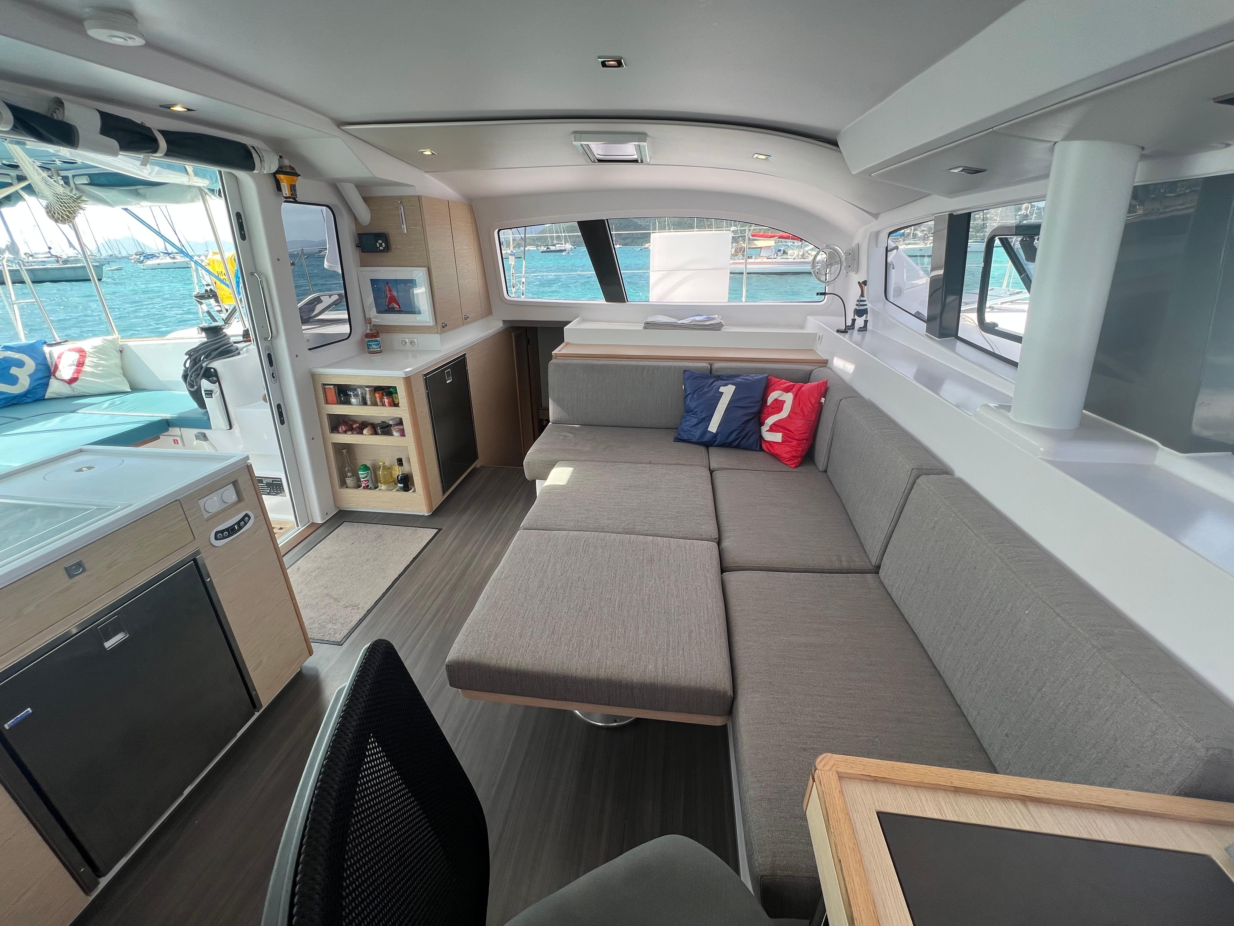 2024 Outremer 45 yacht interior with modern seating, large windows, and nautical decor.