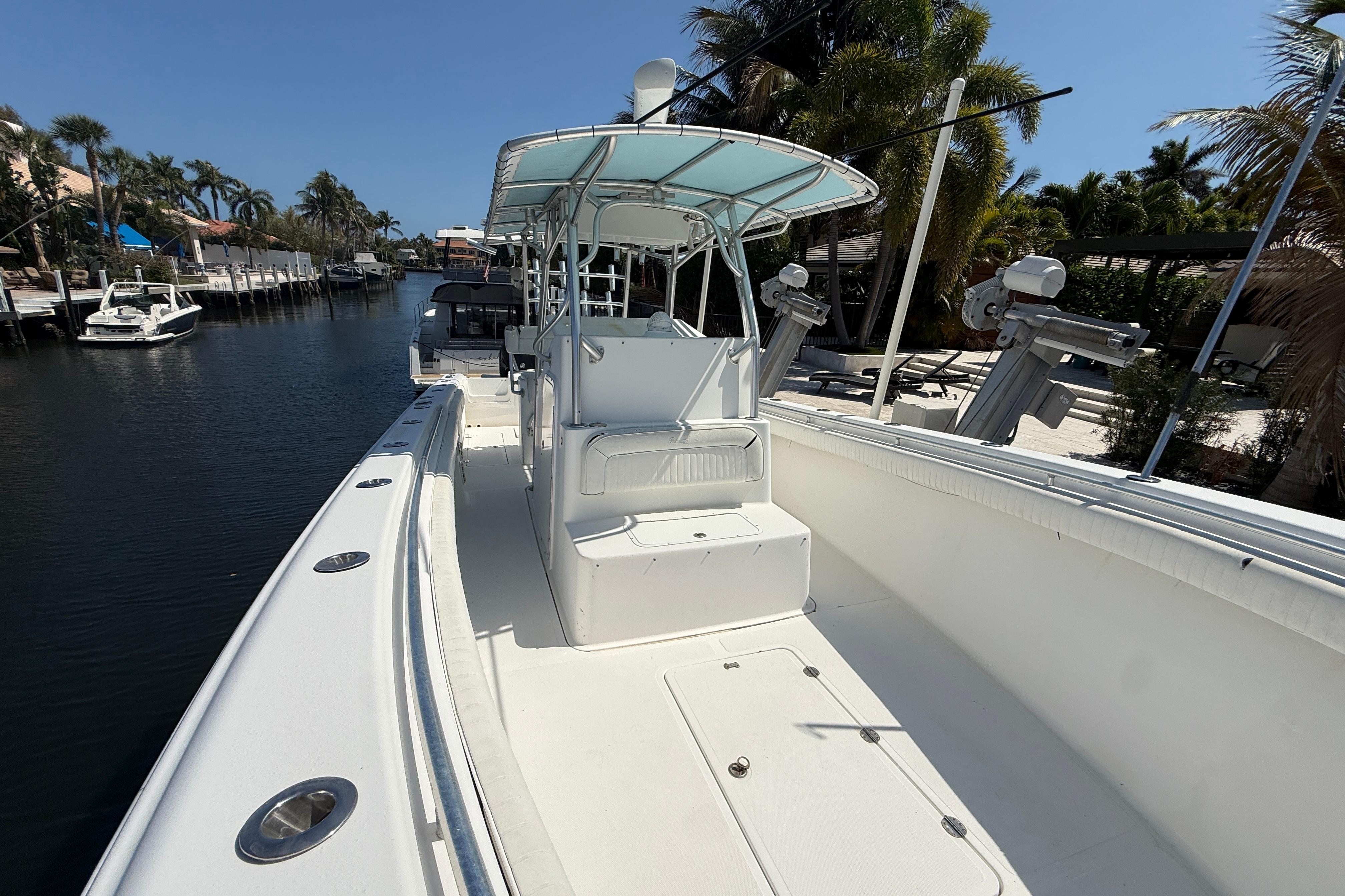2003 Palmetto 33 Adventure boat docked on a sunny canal with palm trees.