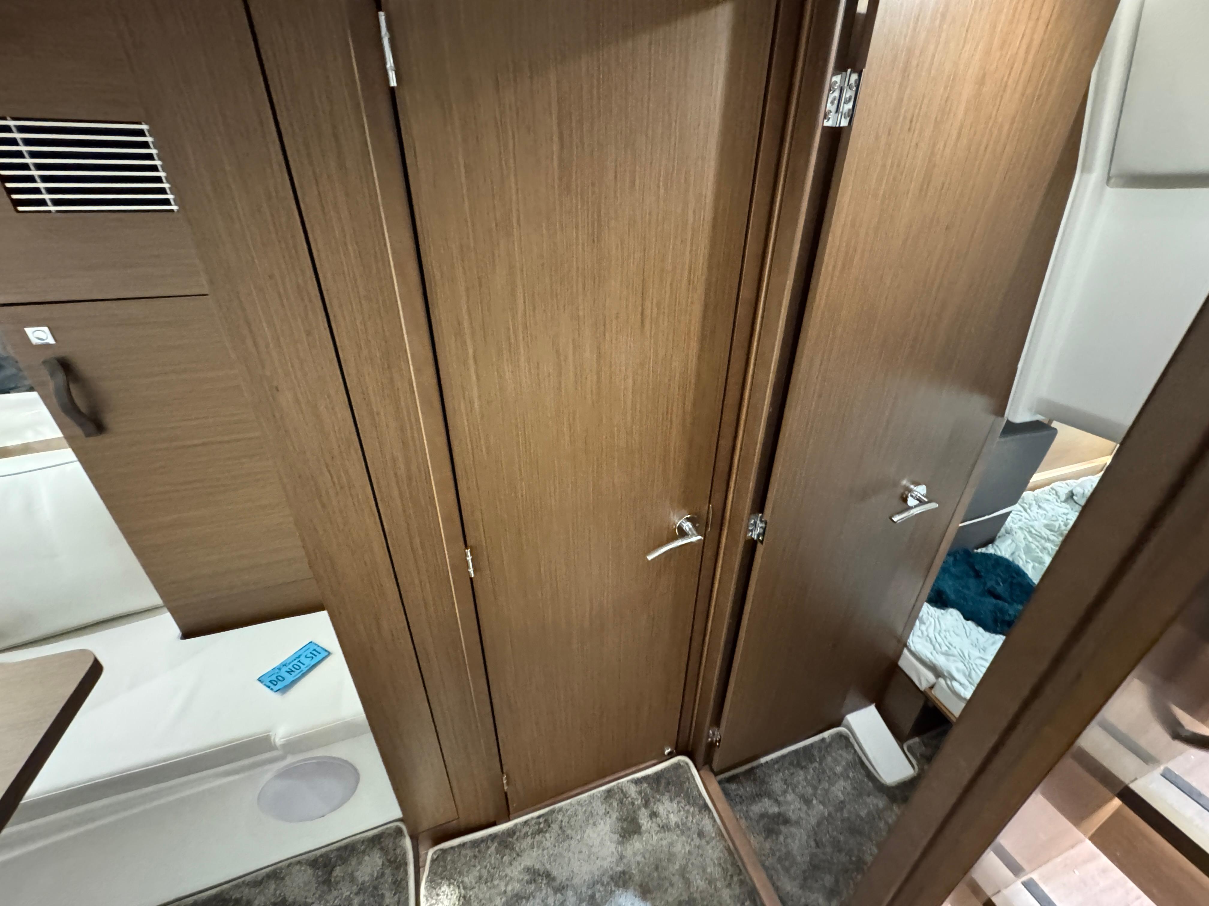 Interior of 2025 Jeanneau Leader 10.5 WA Series 2, featuring wooden cabinetry and carpeted flooring.