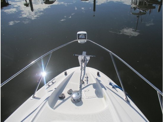 Bow of 2000 Bayliner 3055 Ciera Sunbridge reflecting on calm water.
