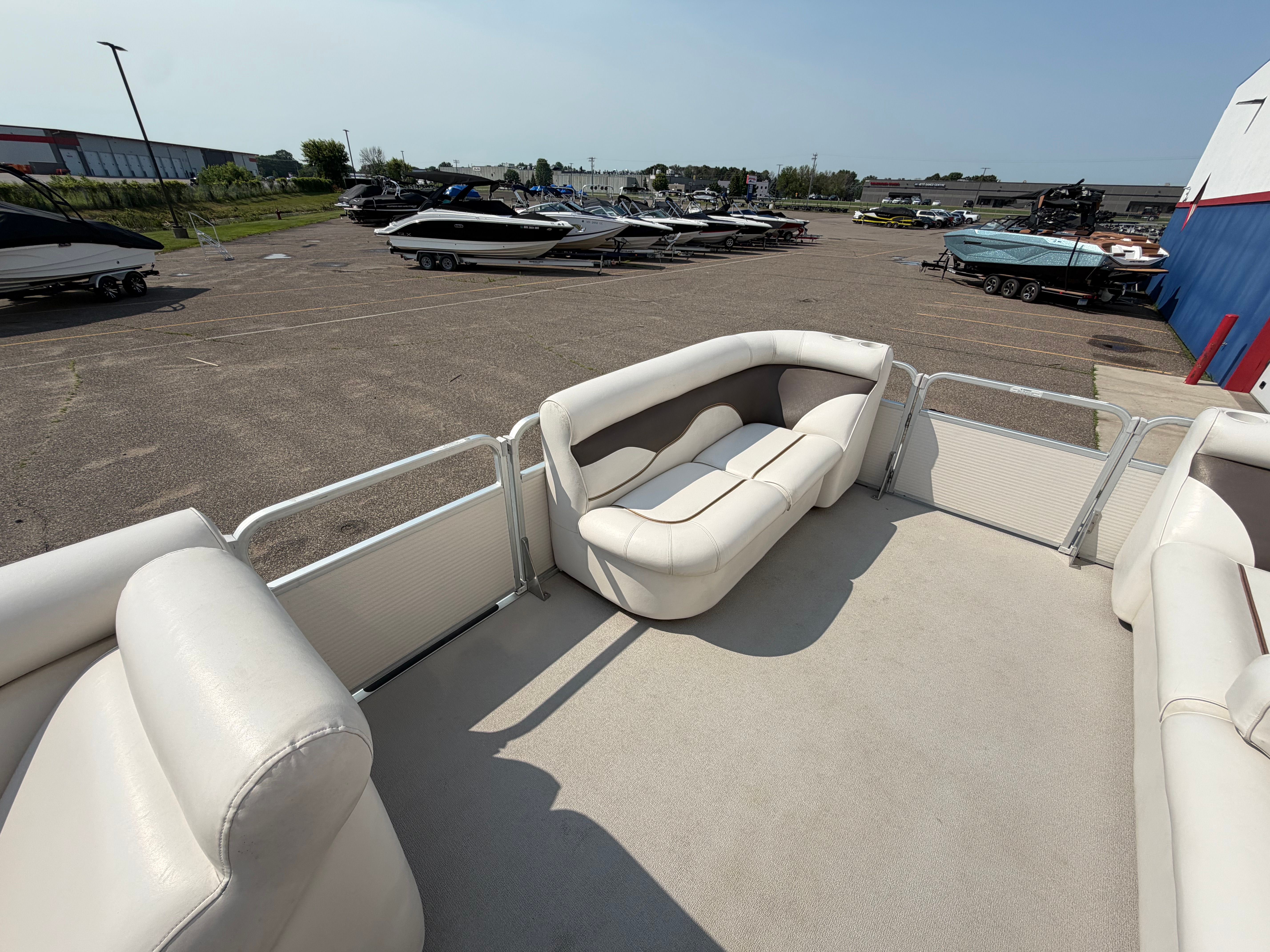 The image shows the deck of a 2007 Premier 225 Sunsation pontoon boat with beige seating.