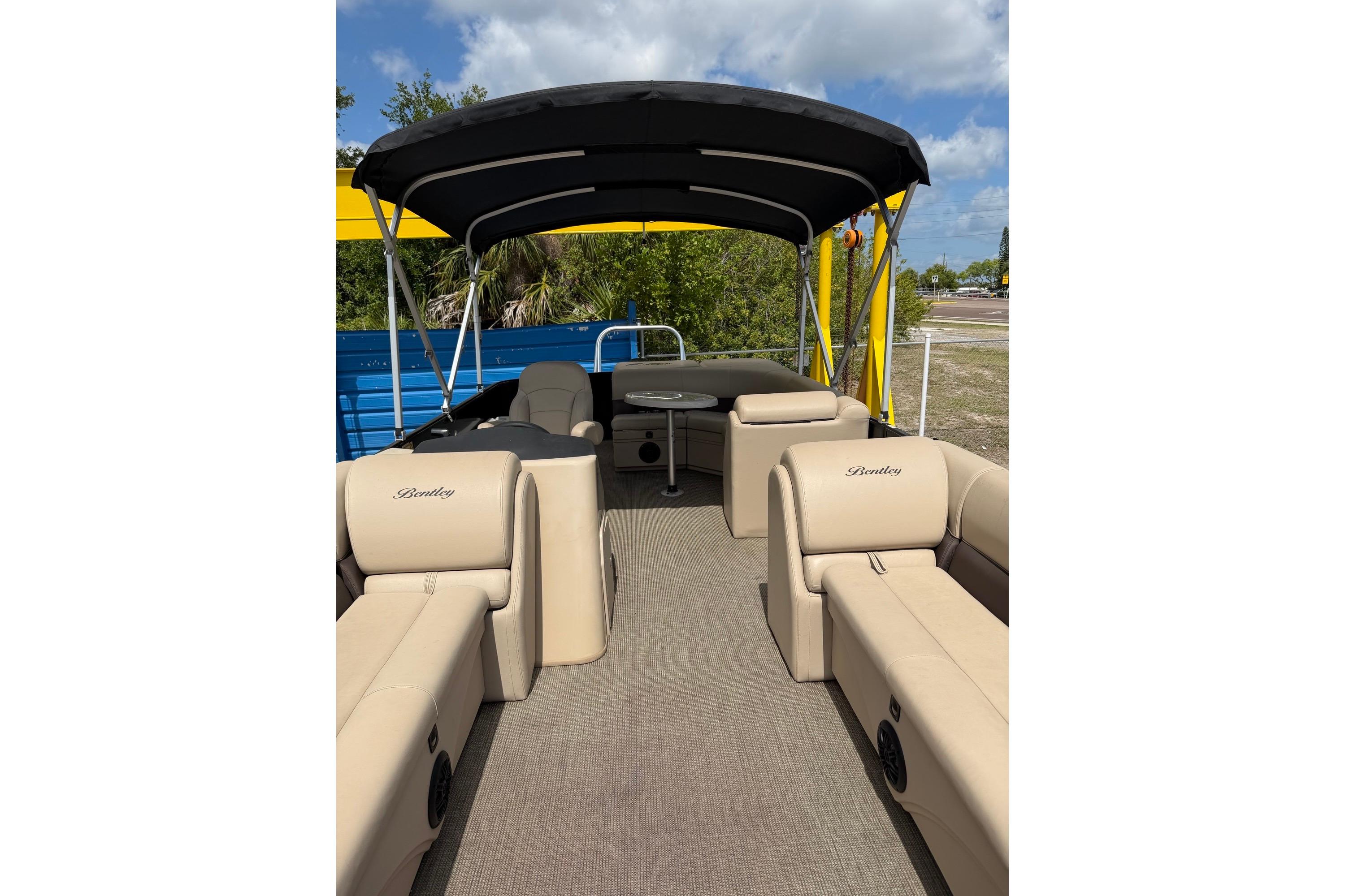 2022 Bentley Pontoons 240 CRUISE interior with beige seating and canopy, set against a sunny backdrop.