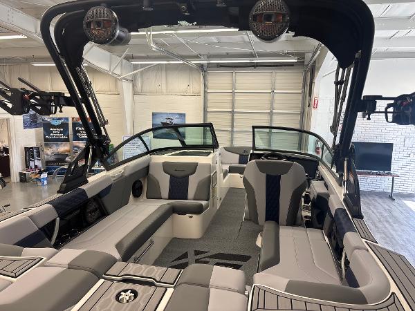 2025 MasterCraft XT22 boat interior with modern seating and sleek design in a showroom.