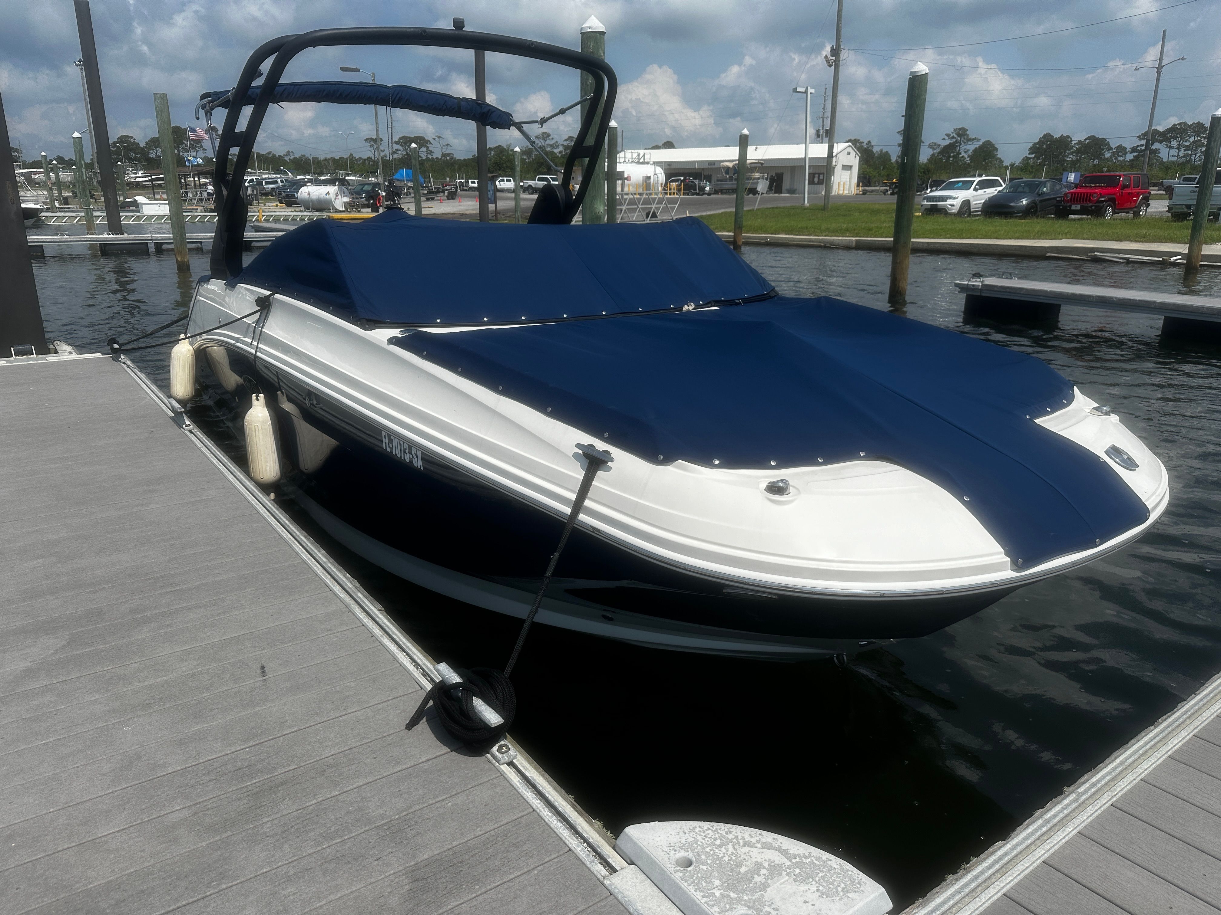 Sea Ray SDX 250 Outboard 2020 at dock, covered.