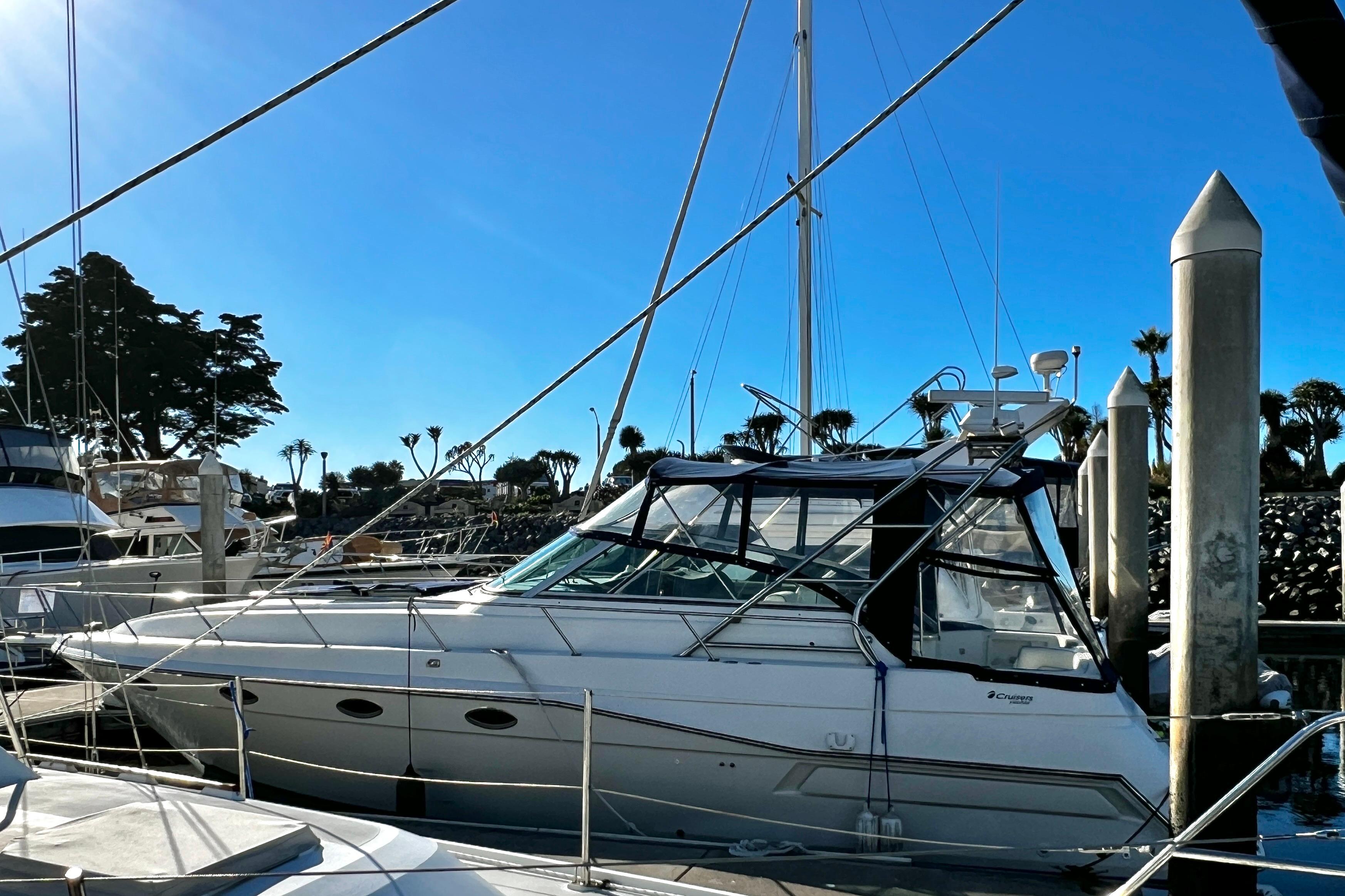 1989 Cruisers Yachts 3670 Esprit docked at marina under clear blue sky.