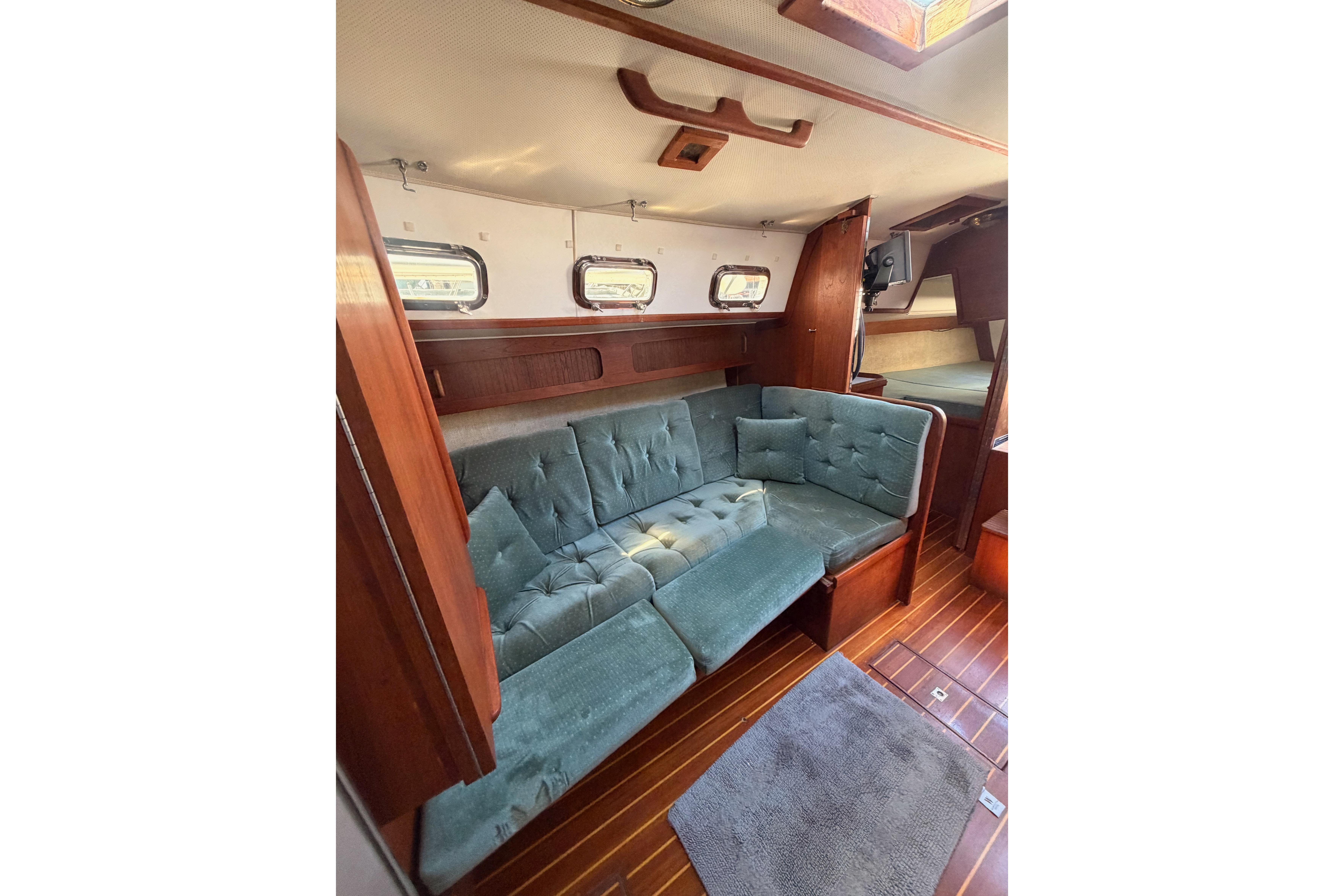 Interior of 1991 Caliber 33 sailboat with cozy seating and wooden flooring.