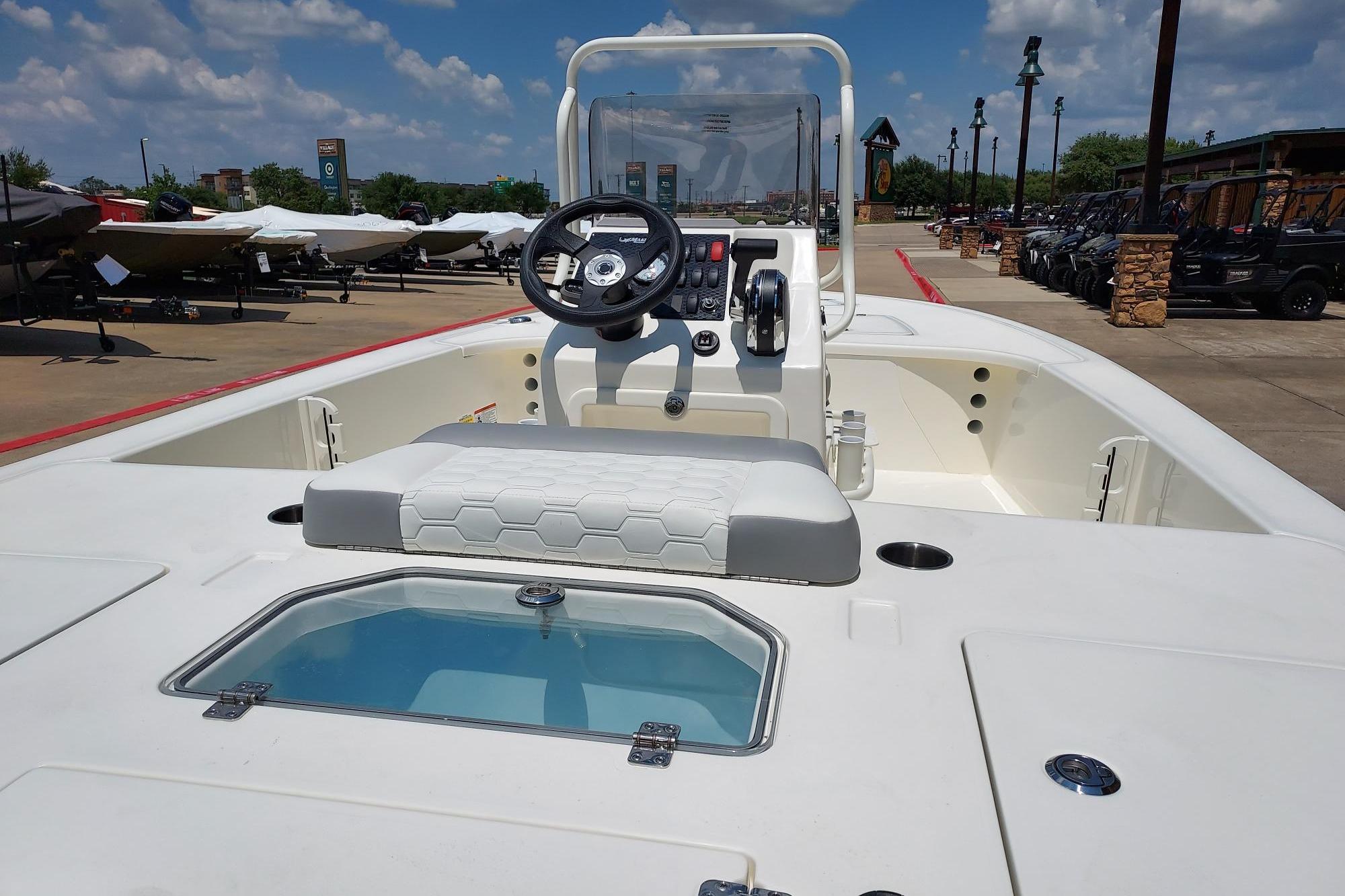 2026 Mako Pro Skiff 18 boat with console and seating, displayed outdoors under a clear sky.