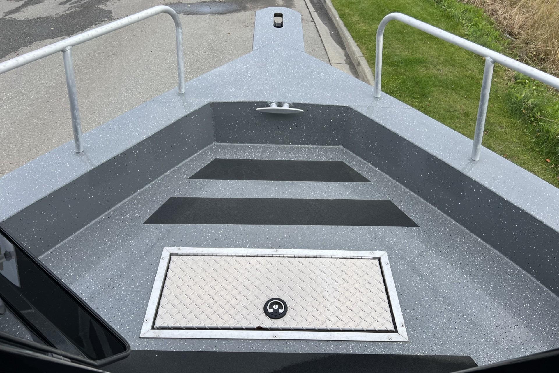 2024 Spartan 220 Maximus boat deck with non-slip surface and storage hatch.