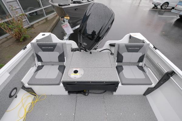 2024 Crestliner 1600 Vision boat interior with seating and motor, parked outdoors.