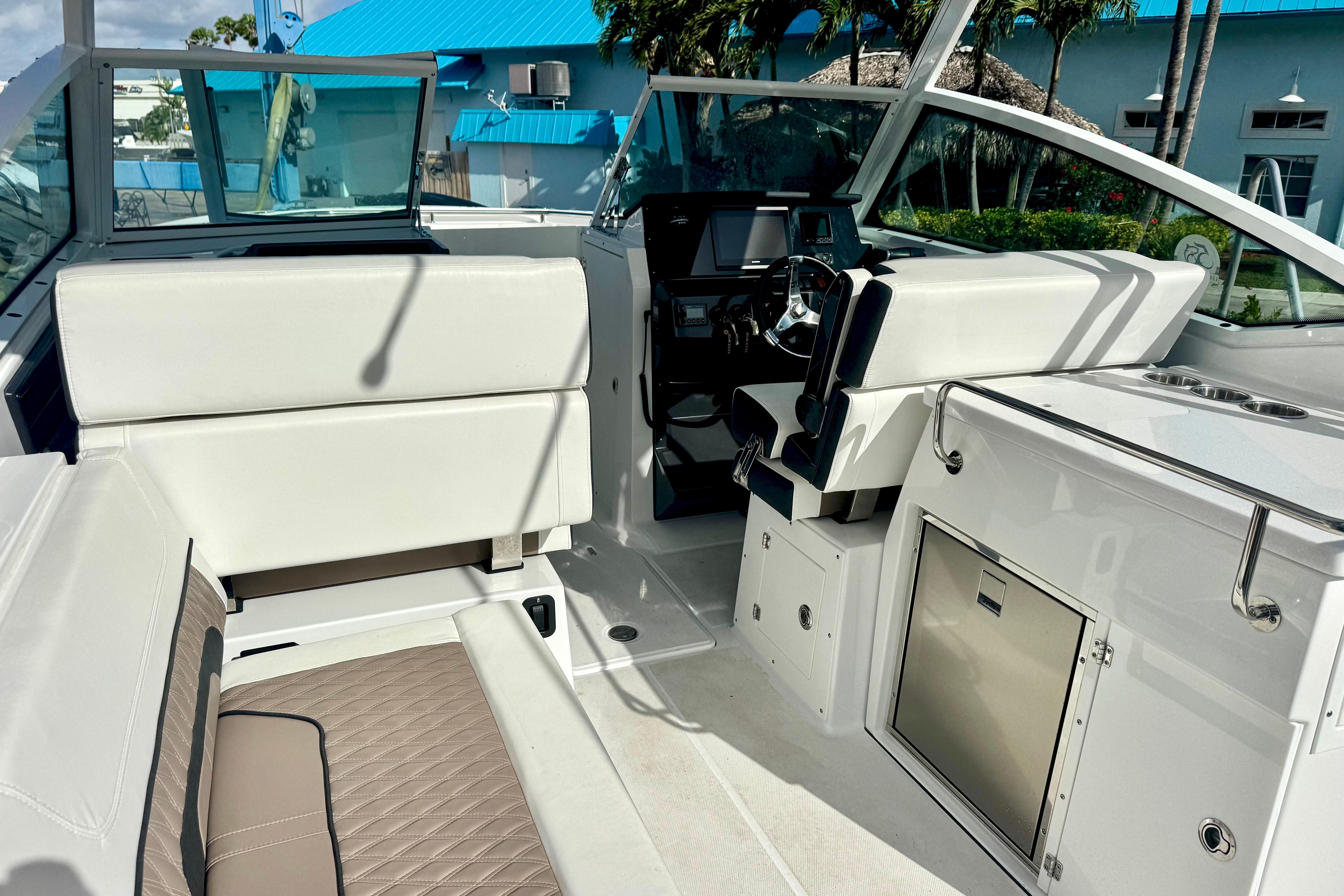 2023 Blackfin 272 DC boat interior with white seating and modern dashboard.