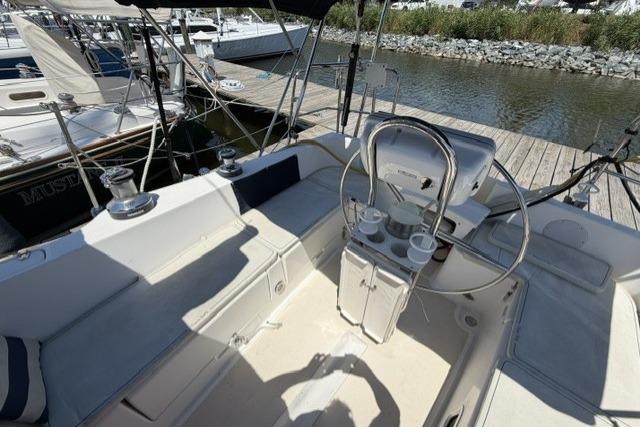 Cockpit of 2002 Saga 43 sailboat with steering wheel and seating, docked at marina.