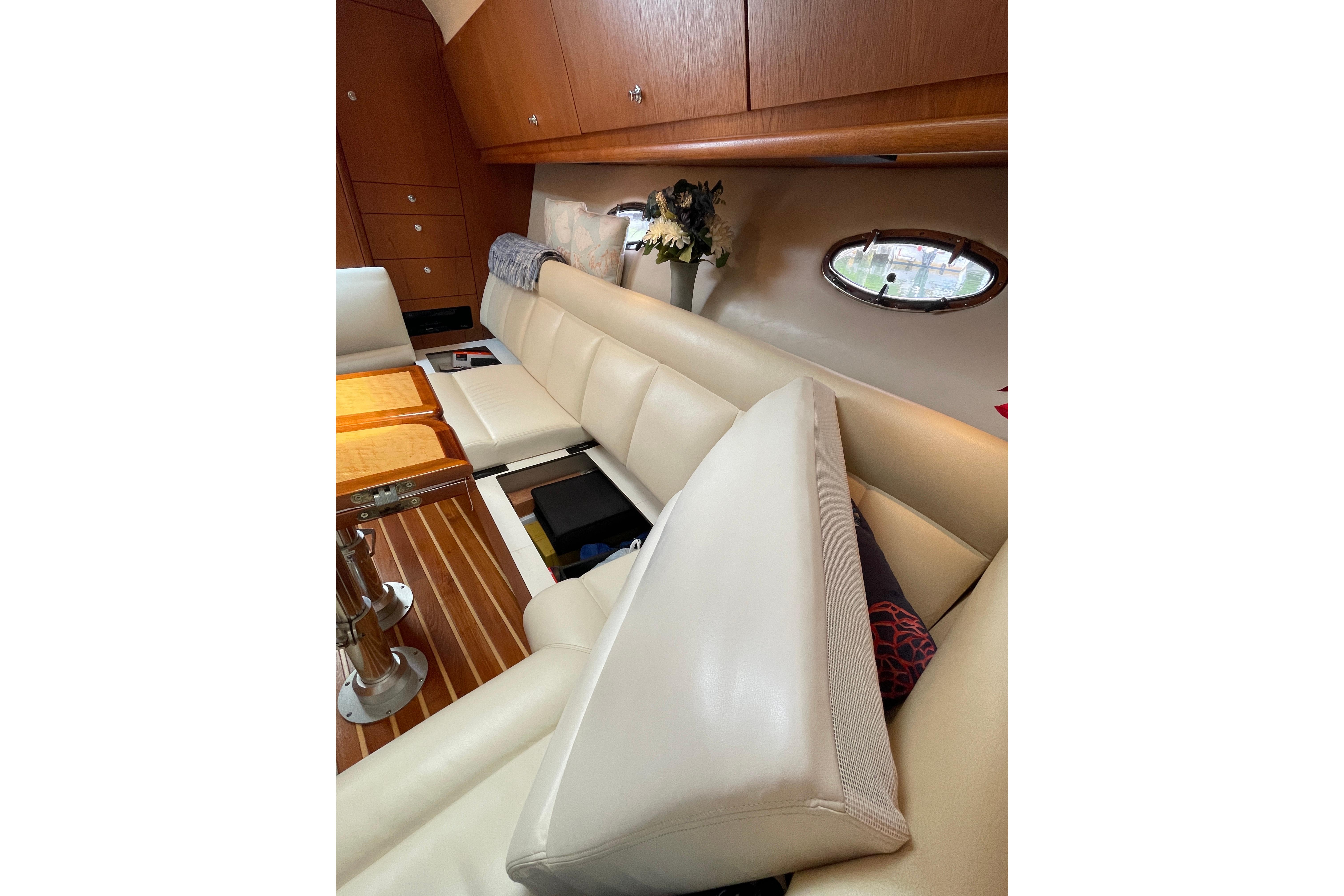 Luxurious interior of 2009 Tiara Yachts 4200 Open with cream leather seating and wooden accents.
