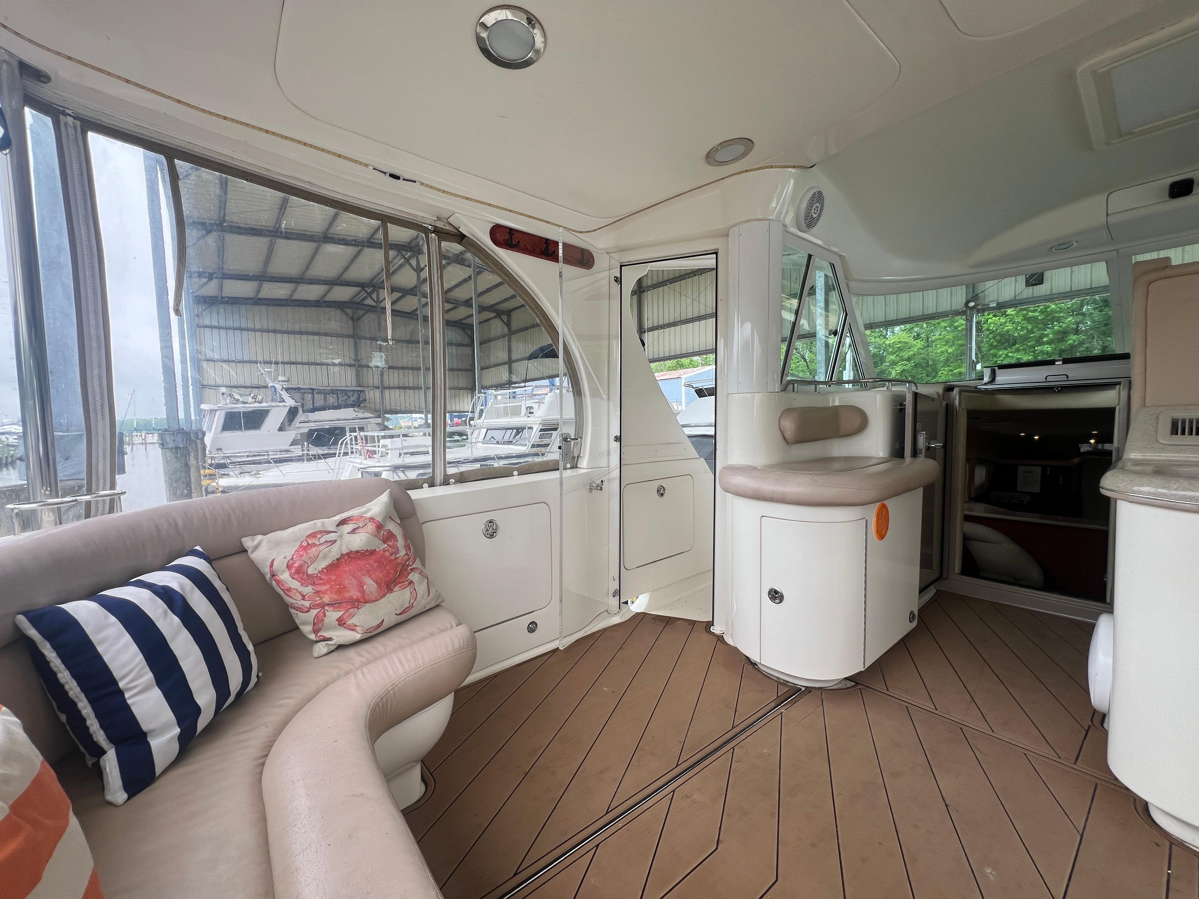 Interior of 2004 Sea Ray 480 Motor Yacht with plush seating and nautical-themed pillows.
