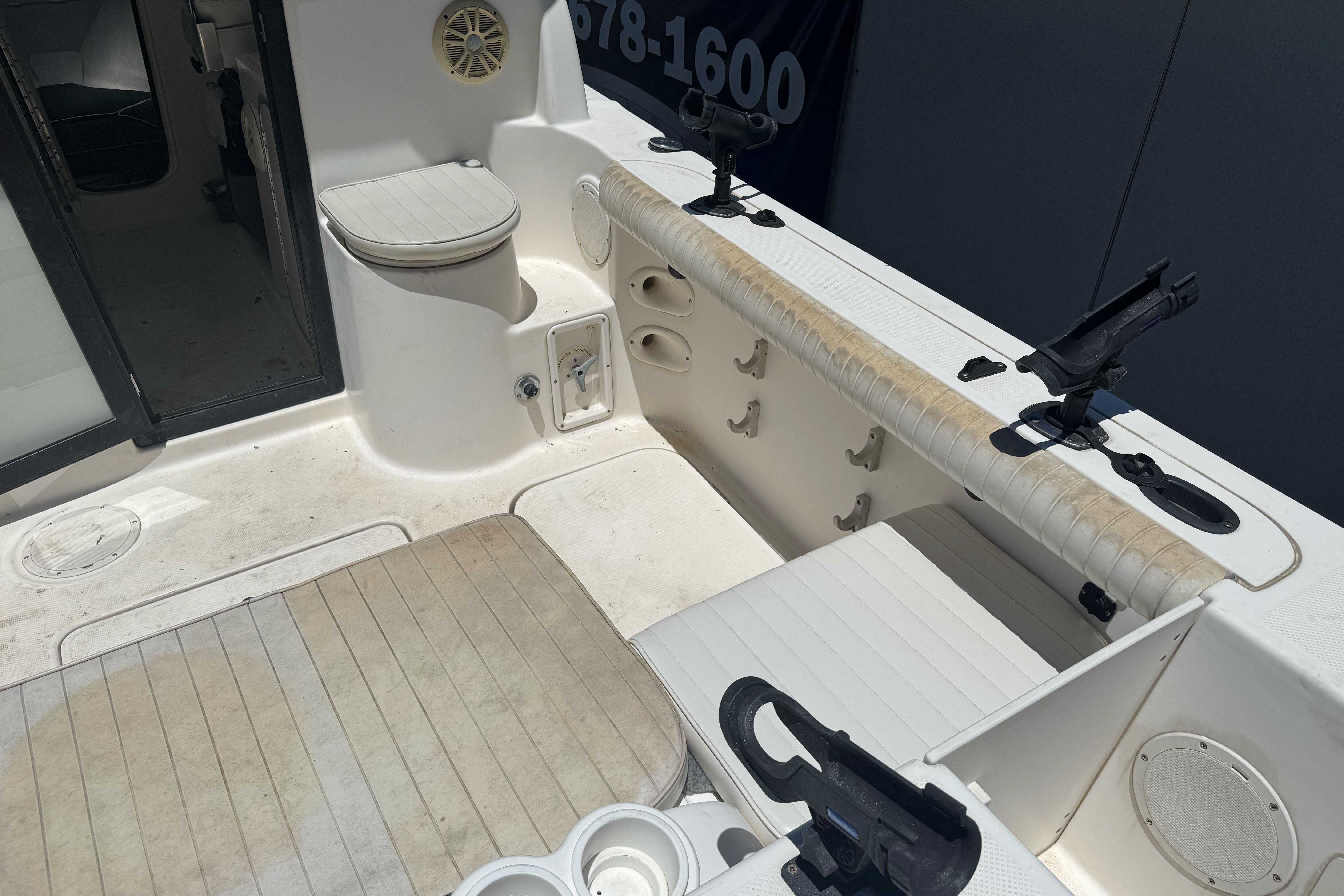 2004 Trophy 2359 WA boat interior with seating, rod holders, and storage compartments.