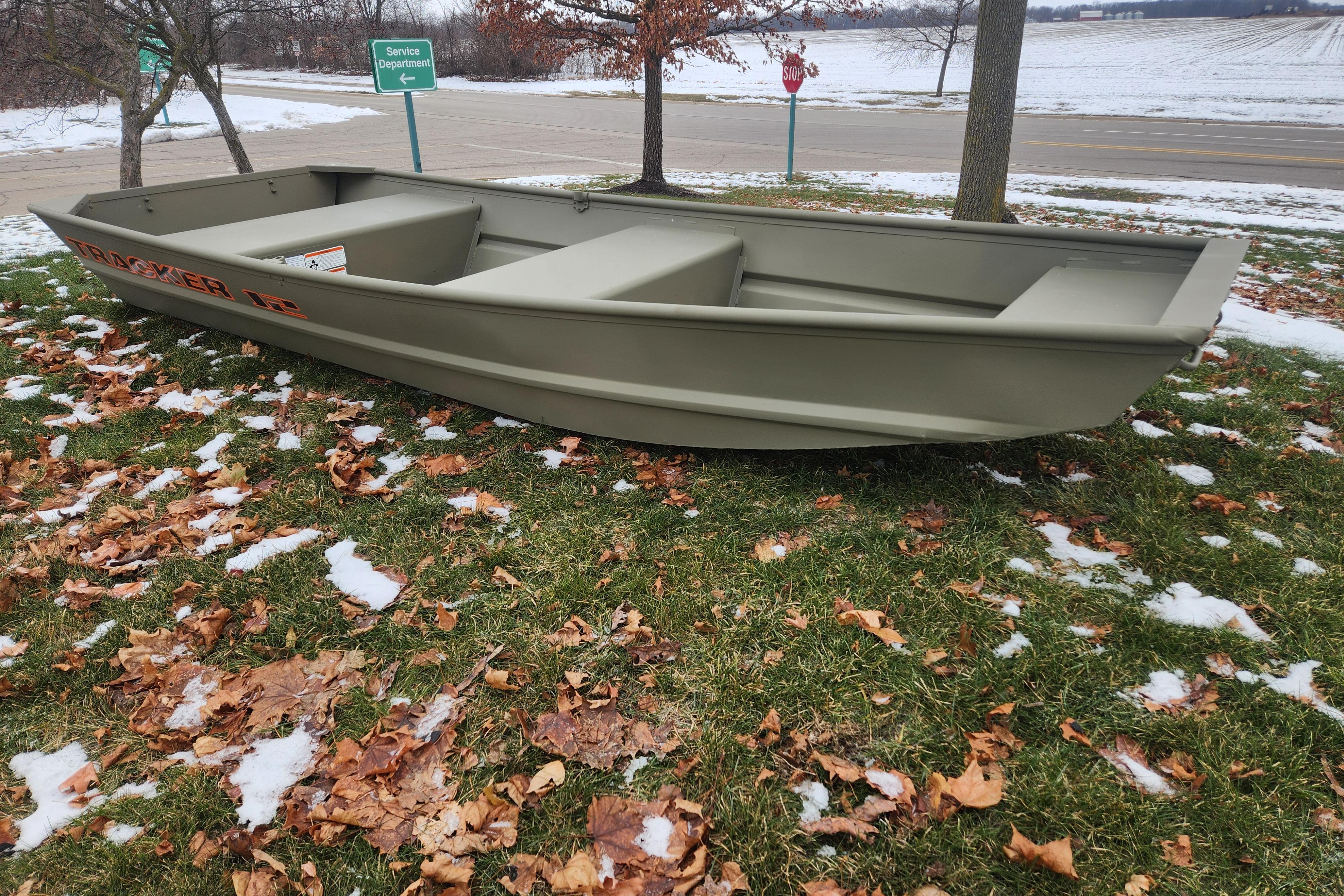 2026 Tracker Grizzly 12 Jon boat on grass with snow and leaves.